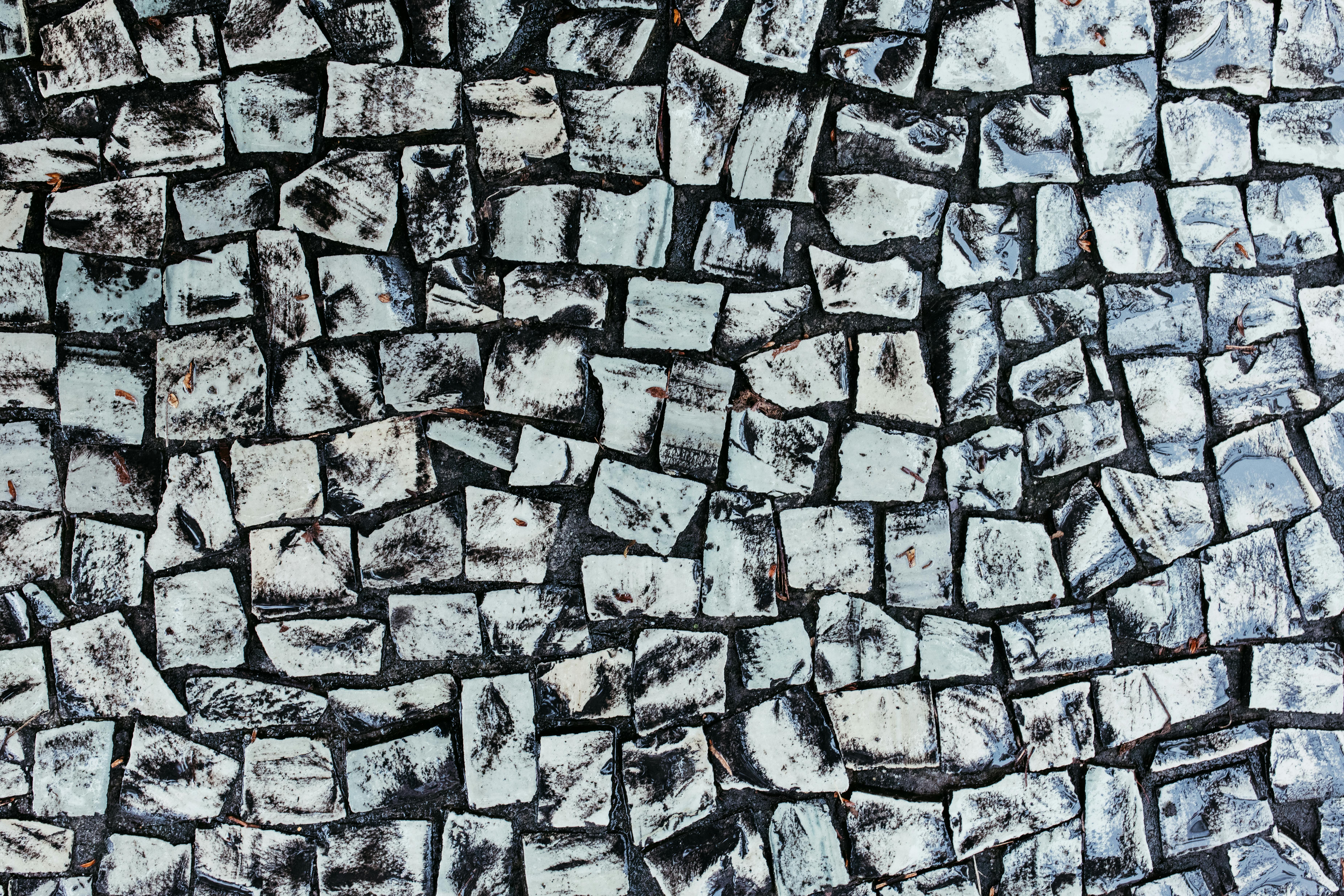Gratis Una fotografía cautivadora de una pared de piedra texturizada con un patrón abstracto, que muestra formas geométricas únicas. Foto de stock