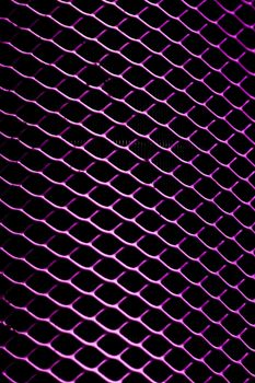 Close-up view of a purple illuminated metal grid pattern with a dark background.