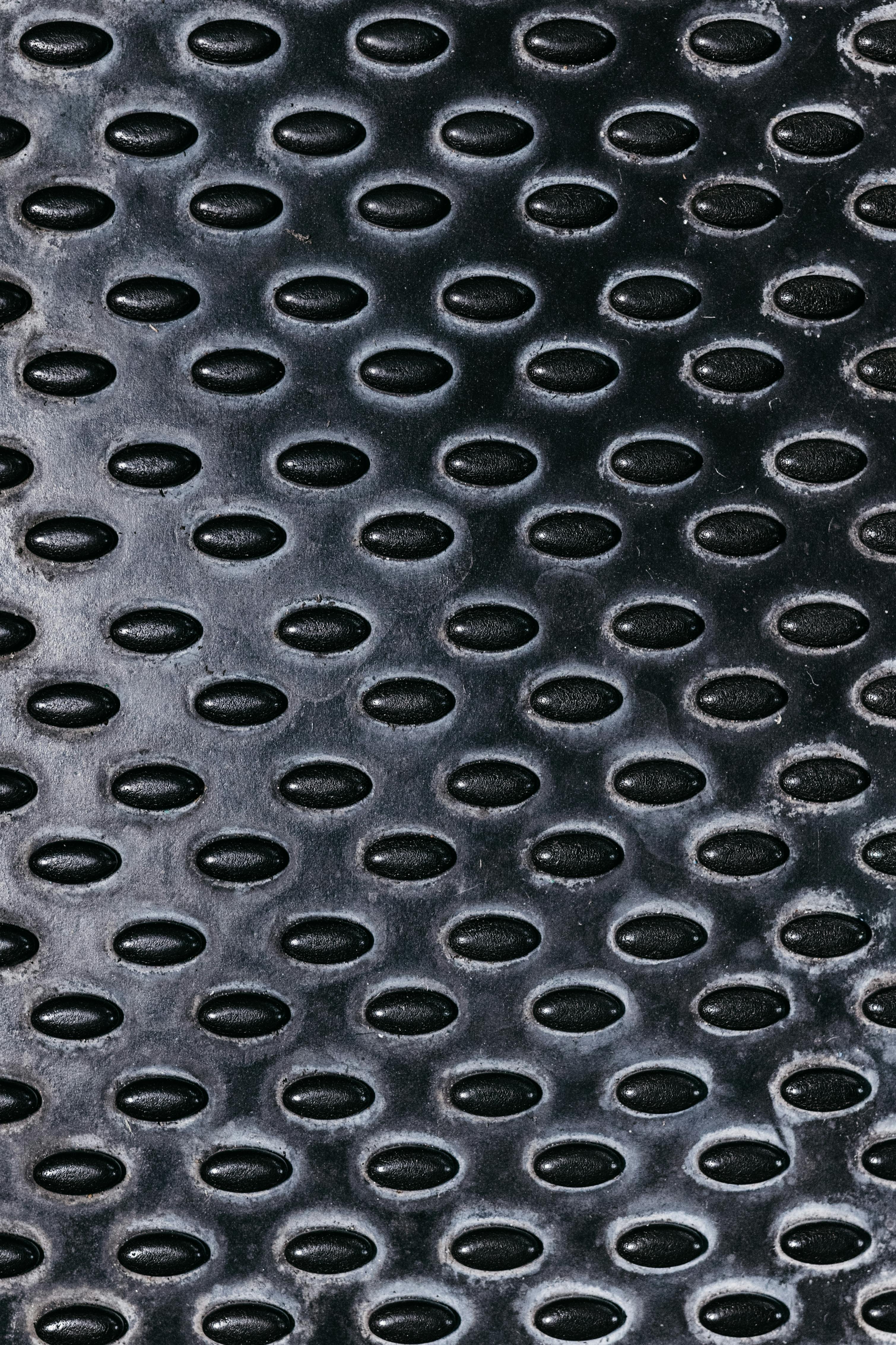 無料 工業用の楕円形のテクスチャを備えた黒色の金属表面の詳細な画像。 写真素材