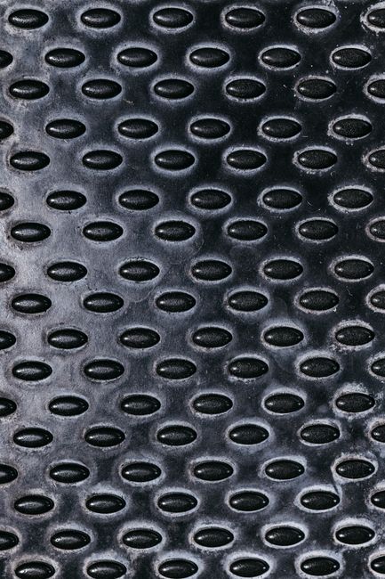 Fotomural Imagen detallada de una superficie metálica negra con texturas ovaladas para uso industrial.