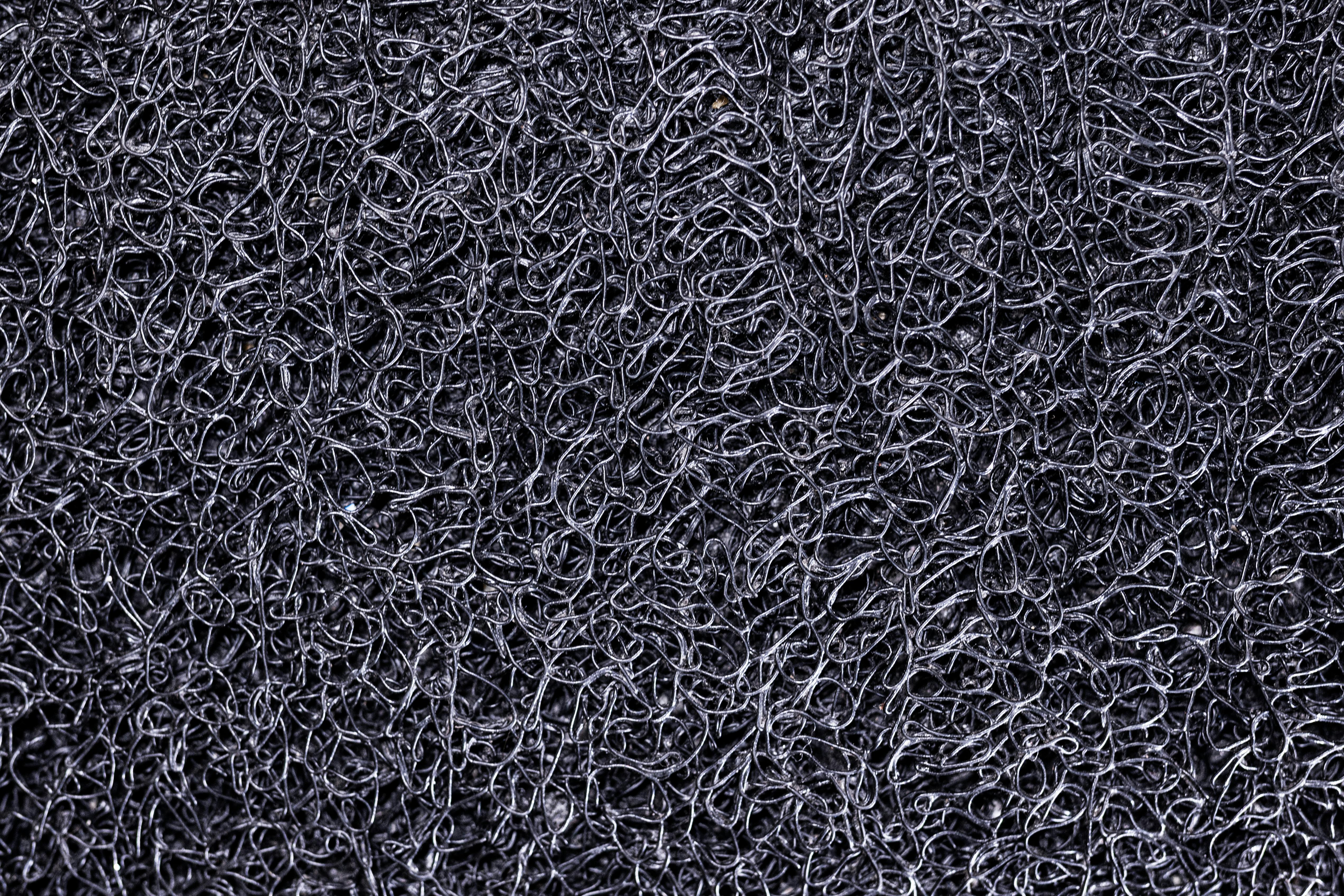 Bezpłatne Zbliżenie na skomplikowaną fakturę powierzchni czarnej siatki ze złożonymi wzorami. Zdjęcie z galerii