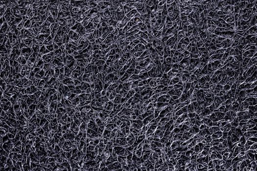 Close-up of an intricate black mesh surface texture with complex patterns.