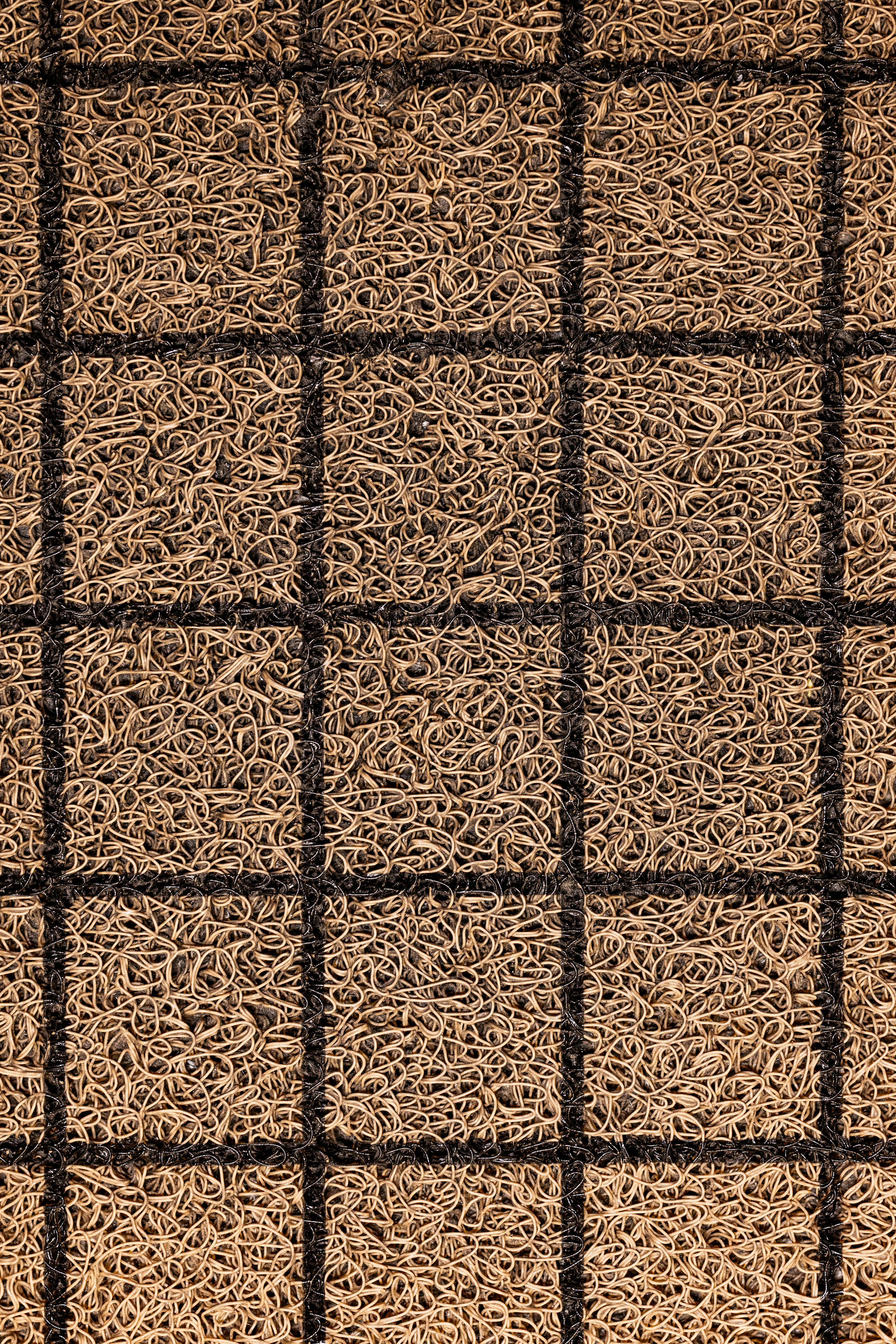 無料 黒い格子模様の茶色のコイヤー製ドアマットのクローズアップ。細かい質感がわかります。 写真素材
