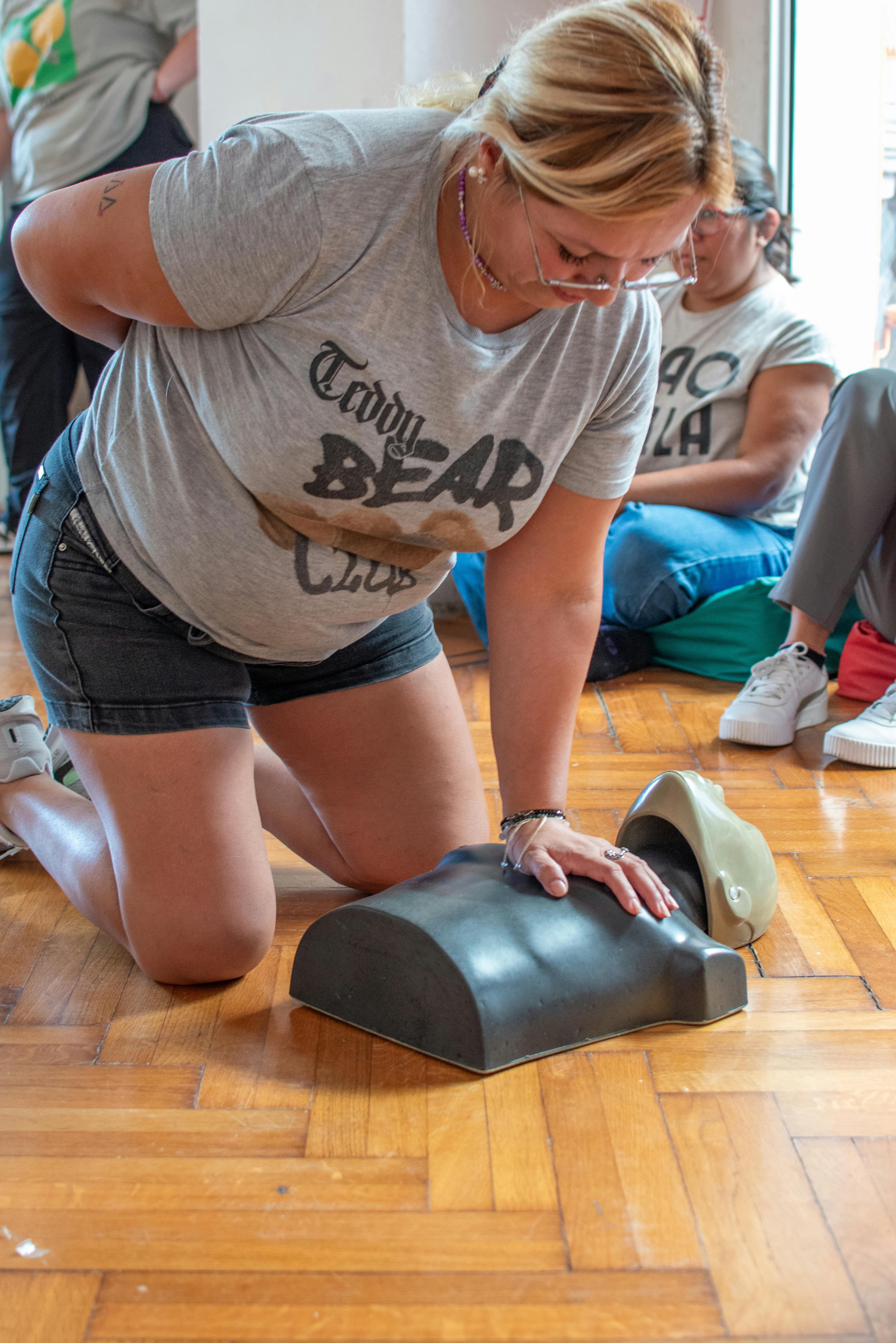 A woman in Buenos Aires practicing CPR on a dummy during a first aid training session.