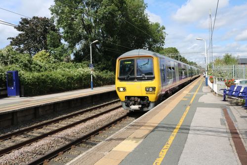 Free A commuter train arrives at Holmes Chapel station under a sunny sky in England. Stock Photo