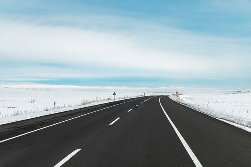 Free A long stretch of road through a snowy winter landscape in Kars, Türkiye. Stock Photo