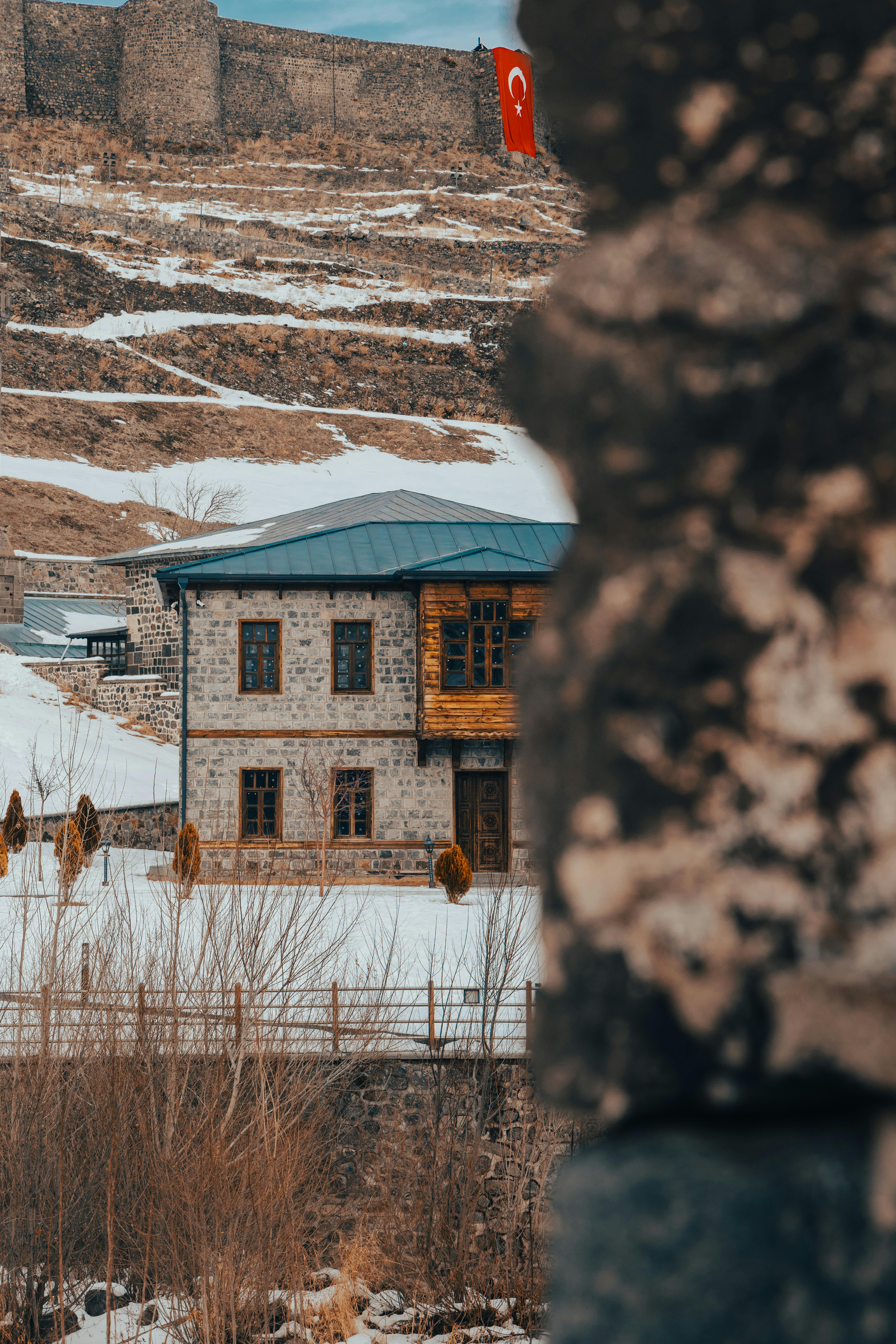Free Scenic winter view of historic architecture in snowy Kars, Türkiye with fortress background. Stock Photo