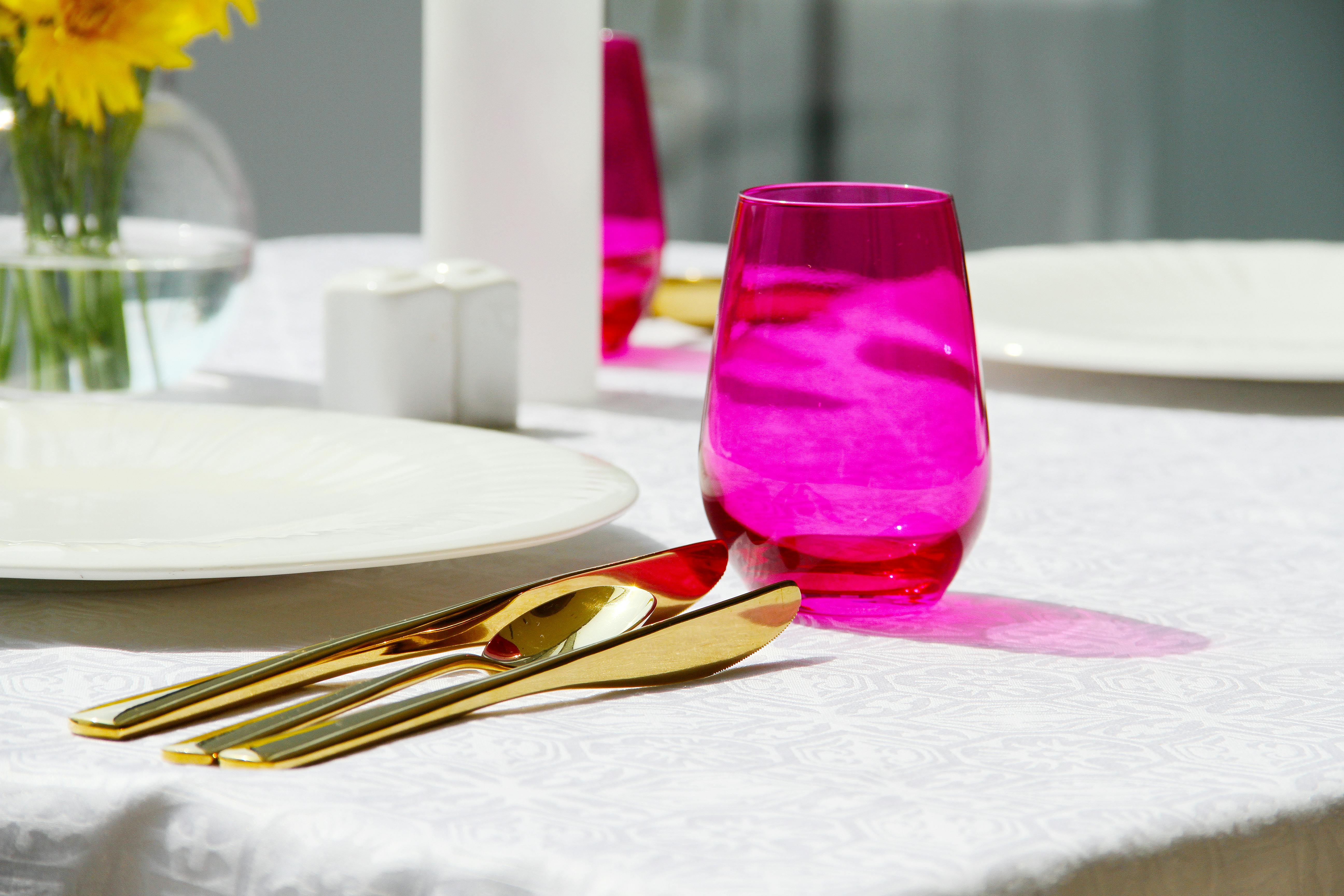 purple drinking glass on white table cloth