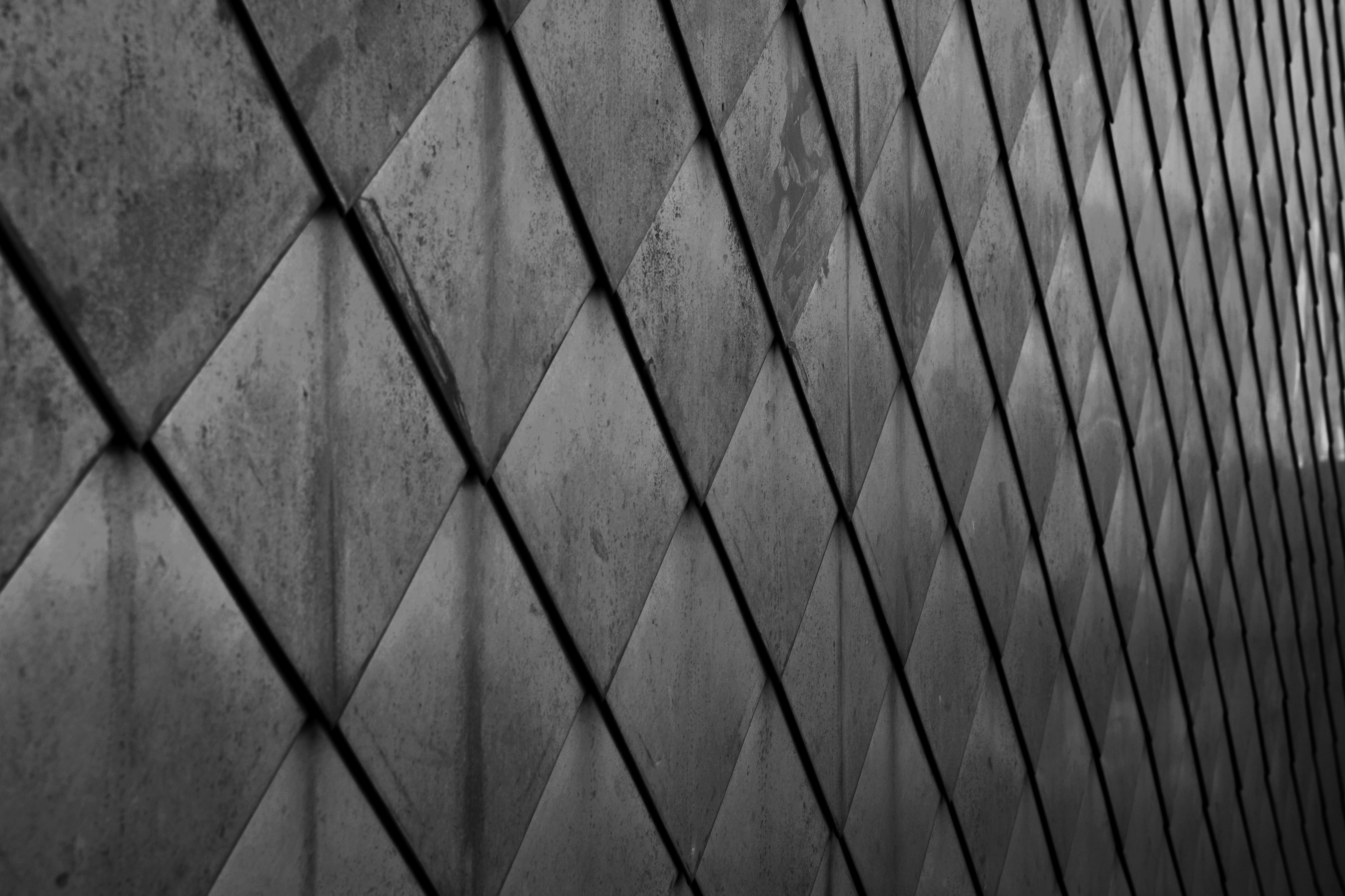 De franc Patró de diamants abstractes en blanc i negre sobre una superfície metàl·lica reflectant que captura ombra i llum. Foto d'estoc