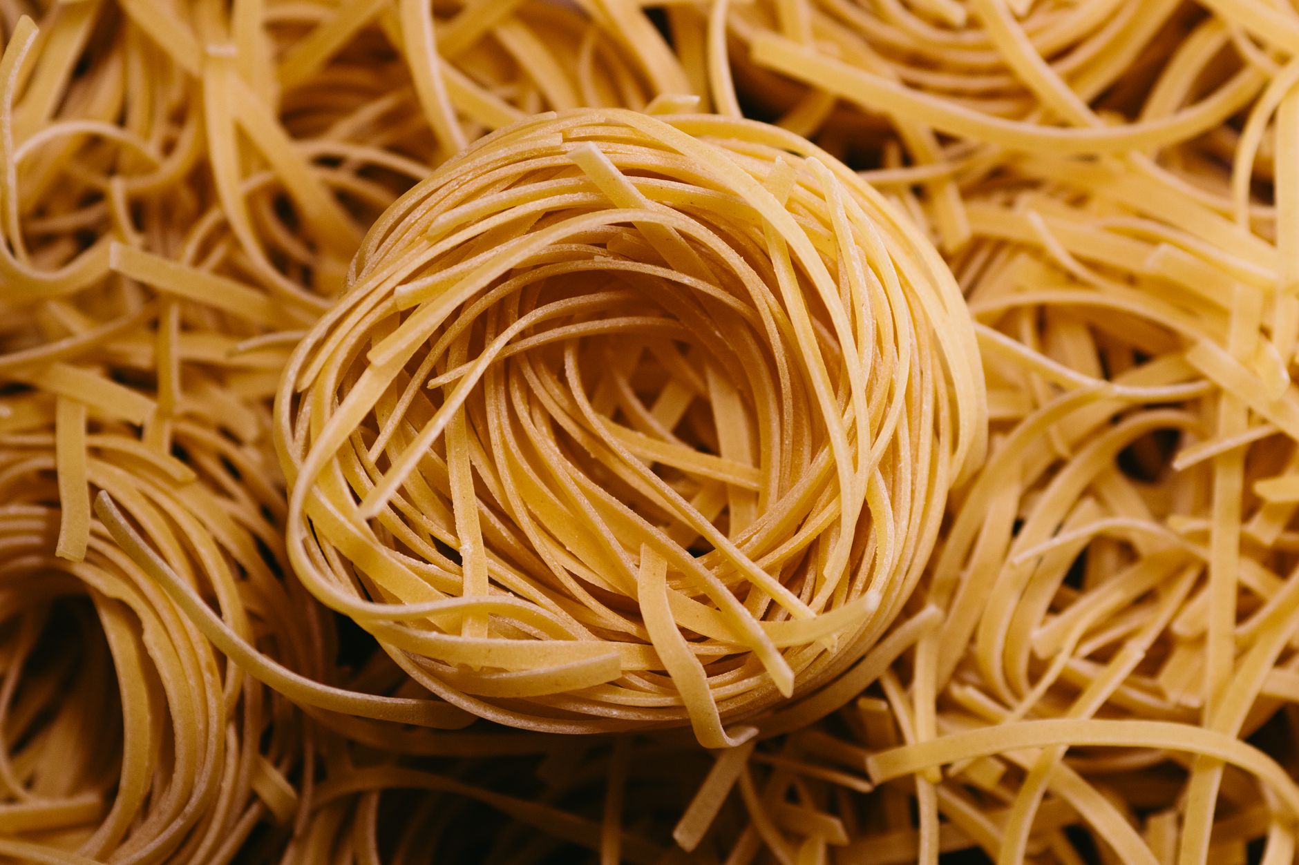 Fresh tagliolini pasta on a wooden board