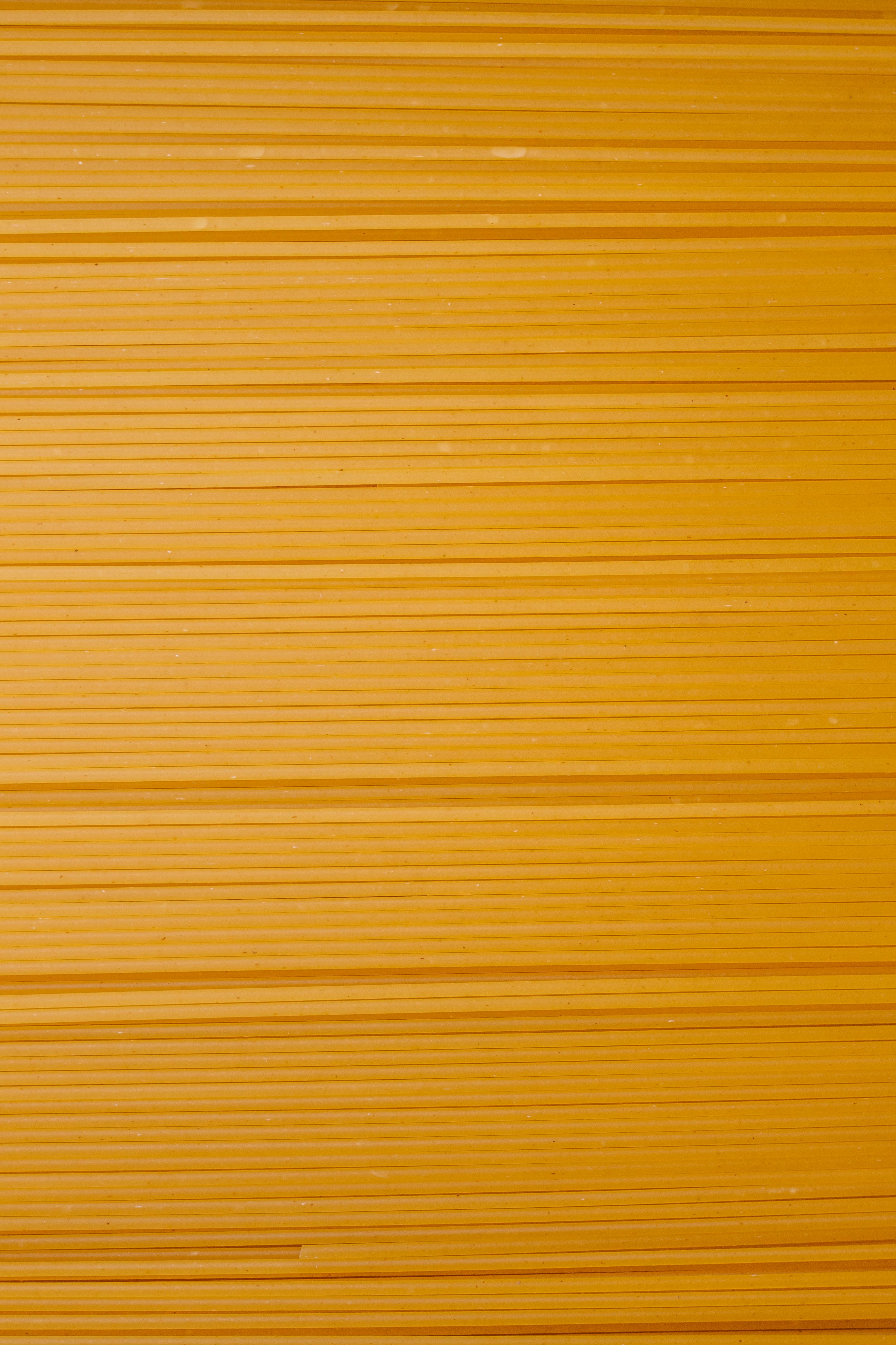 Gratis Immagine ravvicinata e dettagliata di sfoglie di pasta arancione che creano uno sfondo astratto strutturato. Foto a disposizione