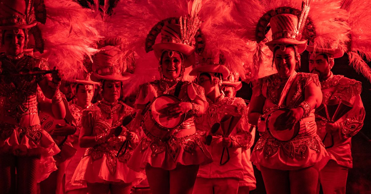 Colorful carnival performers play music and dance, capturing festive spirit with elaborate costumes and vibrant lighting