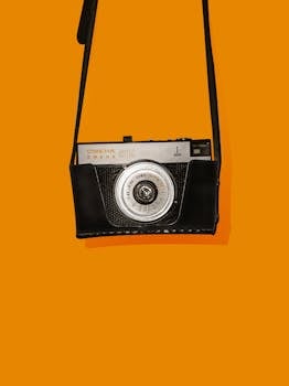 经典的老式模拟相机显示在充满活力的橙色背景上