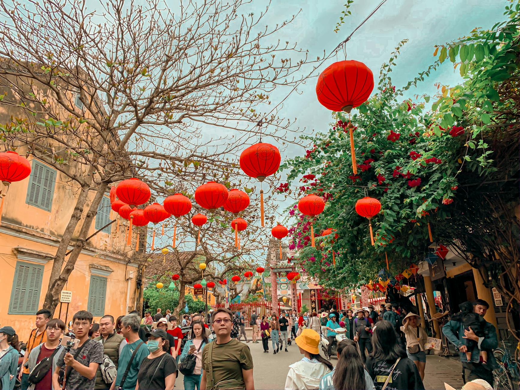Colorful street scene with red lanterns and crowds during Lunar New Year festival.