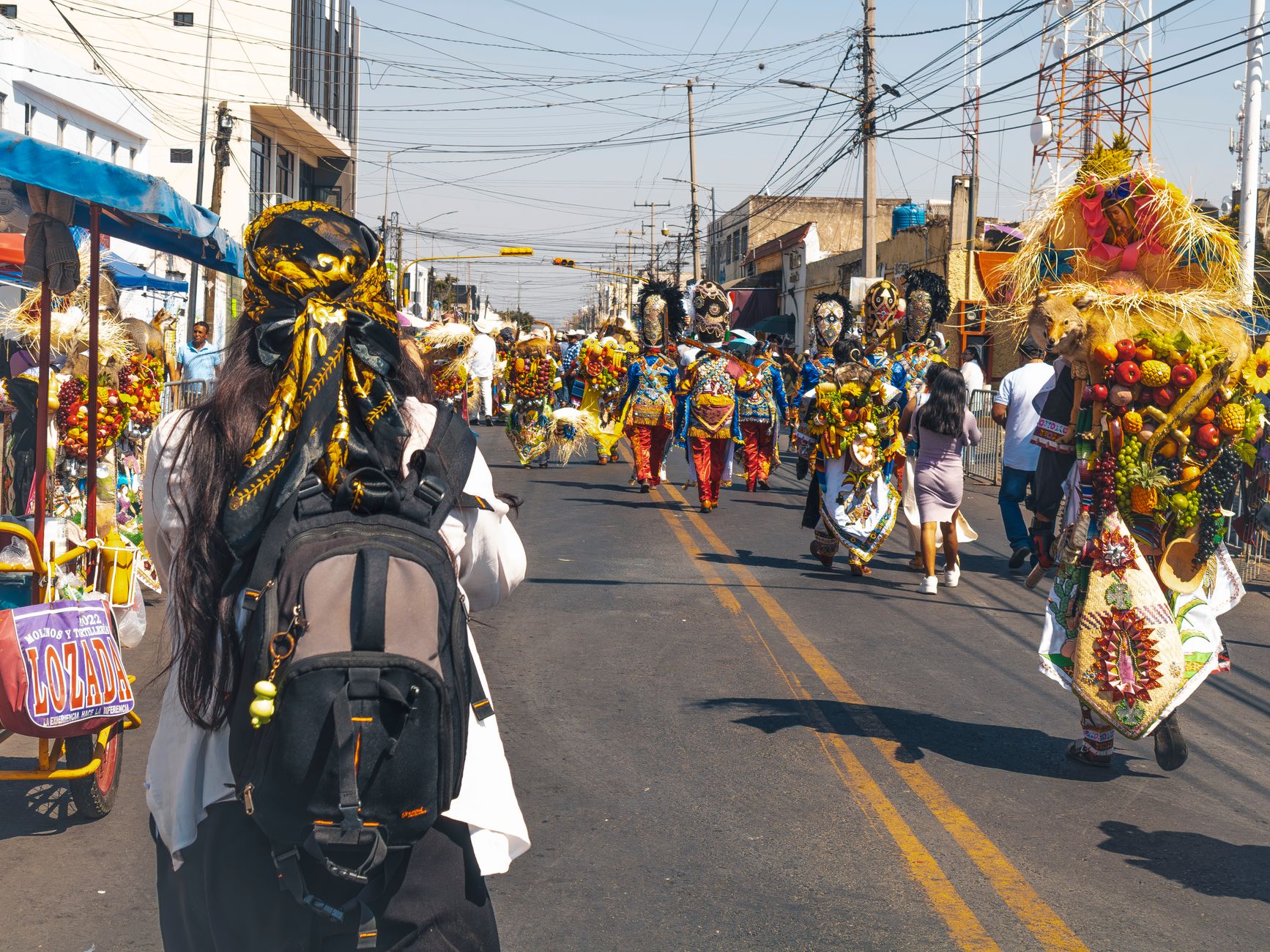 A lively street carnival with people in colorful costumes celebrating outdoors.