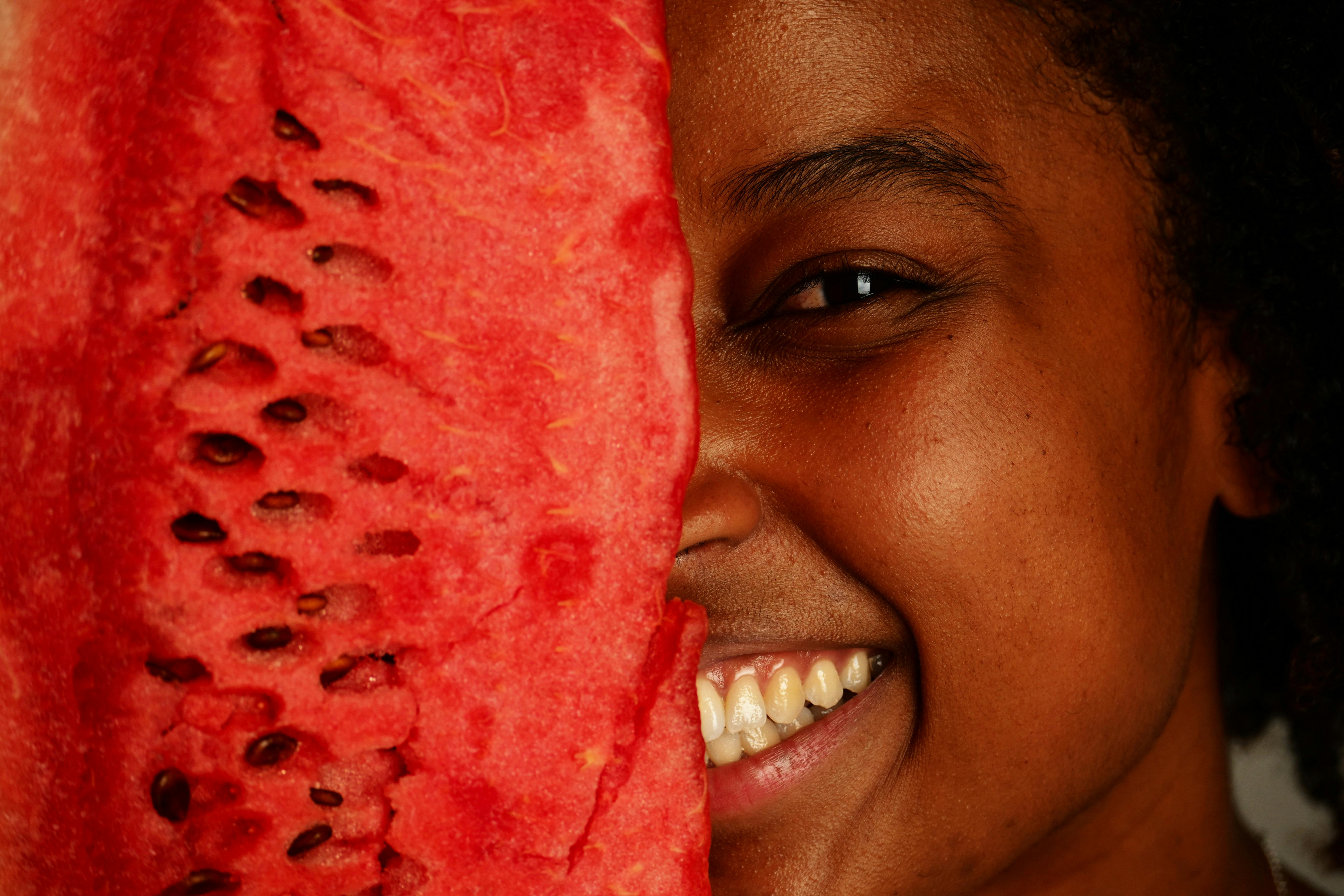 Free A cheerful person holding a watermelon slice close to the face, showcasing a joyful expression. Stock Photo