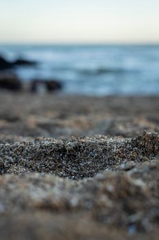 Close-up of coastal sand with ocean in the background at Miramar beach, Argentina.