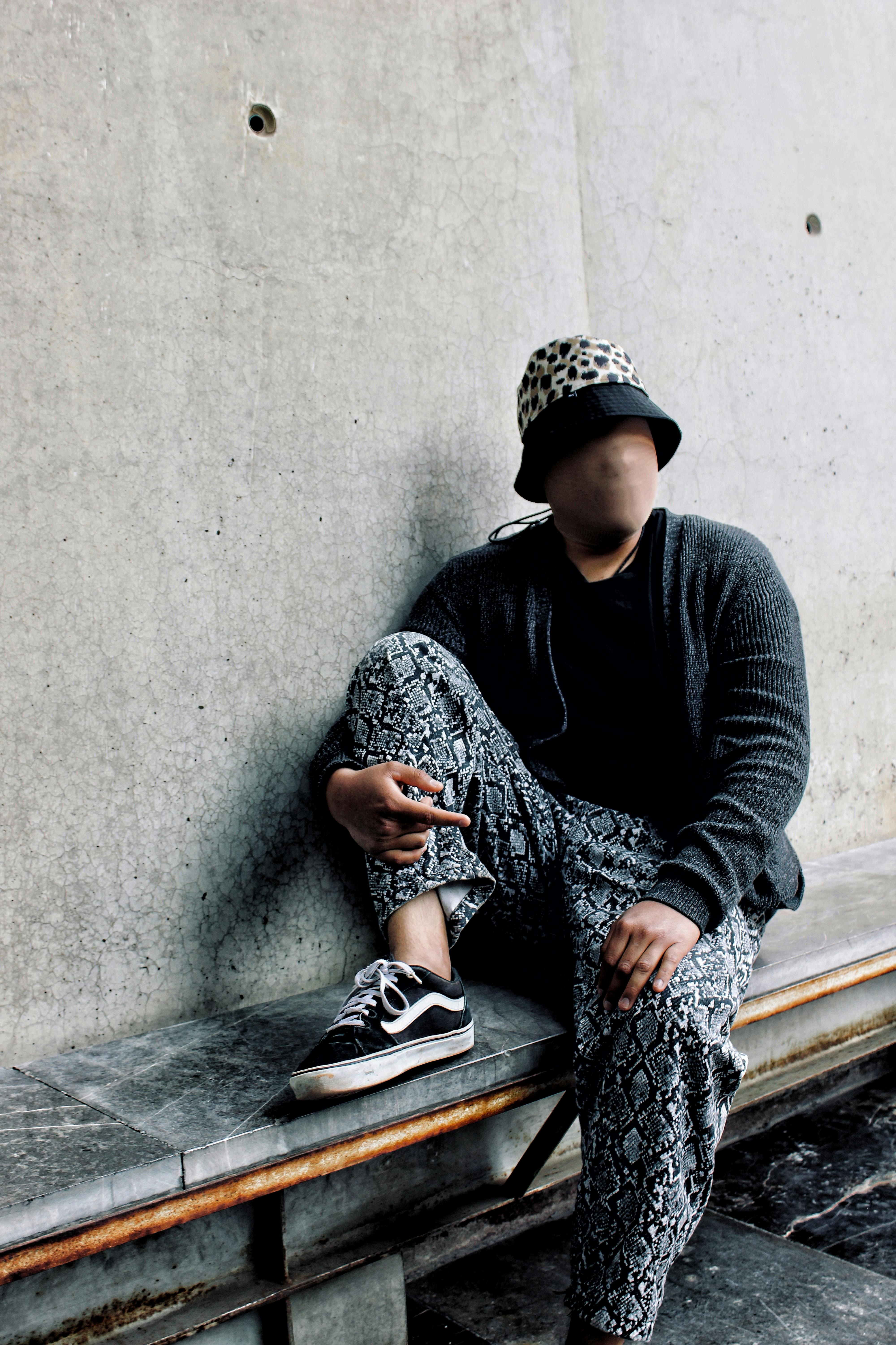 ingyenes Stílusos személy városi hétköznapi viseletben pózol egy betonfalnak. Stockfotó