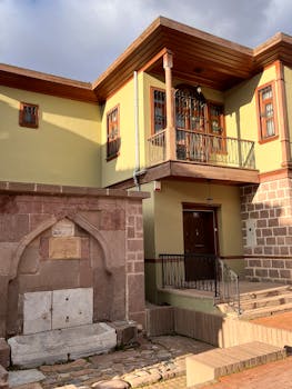 Old Turkish building with a stone facade and wooden balcony in Ankara's historic district.