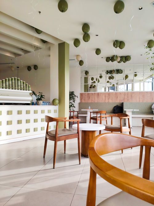 Free Bright and stylish cafe with green balloons and elegant wooden seating. Stock Photo