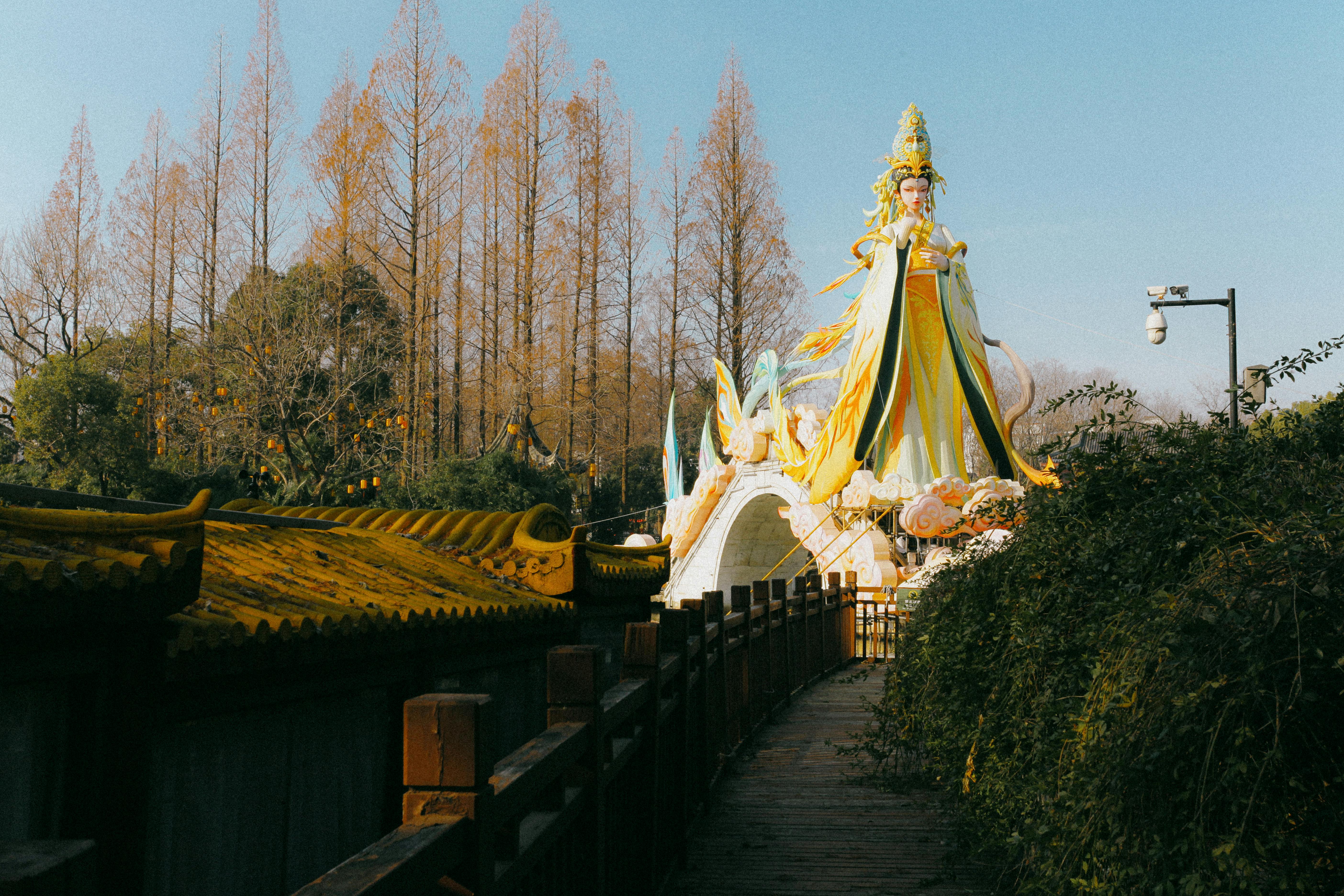 бесплатная Яркая статуя Гуаньинь в Нанкине, Китай, в окружении деревьев и ясного неба. Стоковое фото