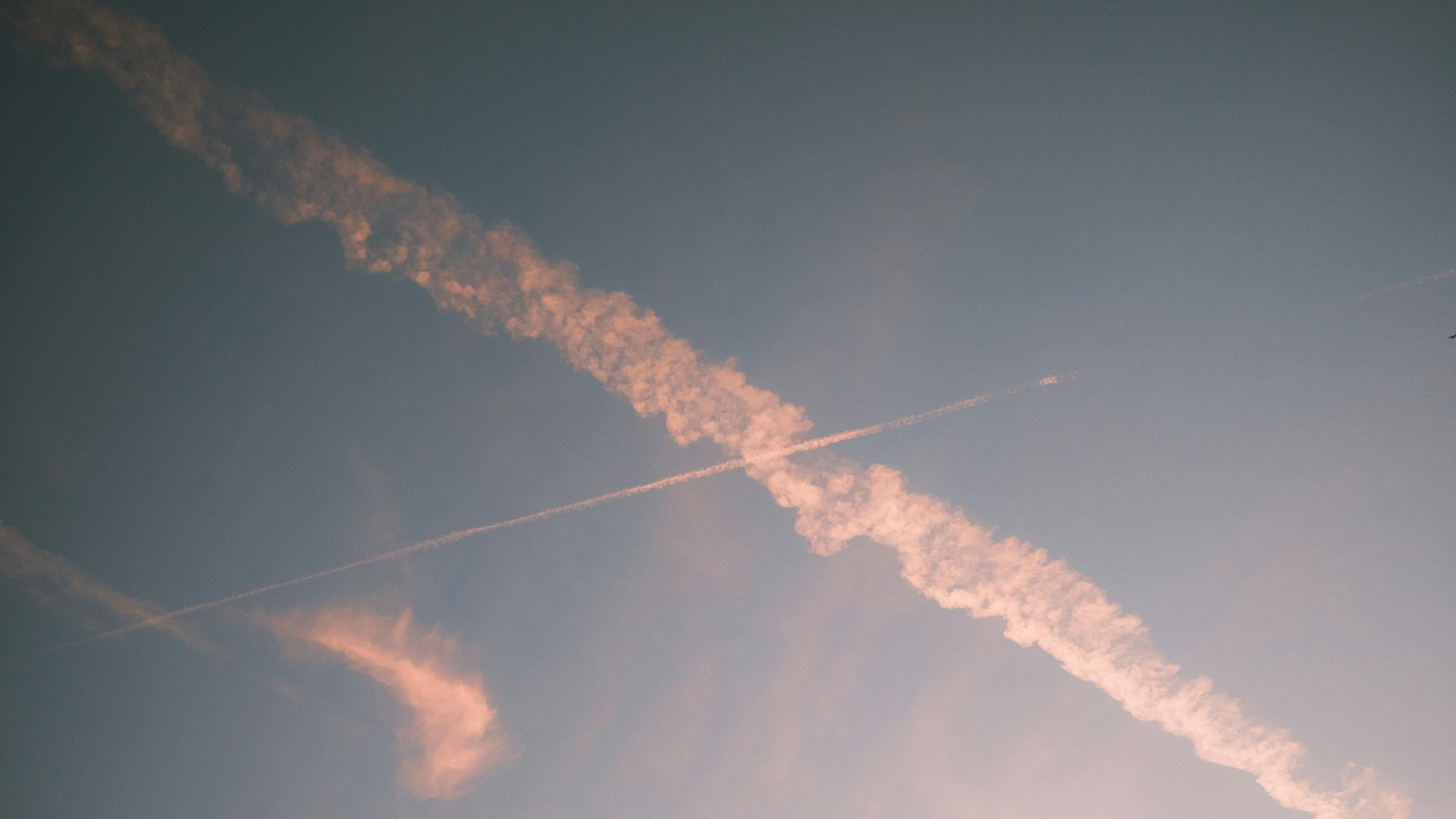 Gratis Vista espectacular de estelas de aviones cruzadas en un cielo sereno y pastel al anochecer. Foto de stock