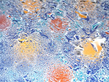 A vibrant abstract image of water droplets on a multicolored surface creating a vivid texture.