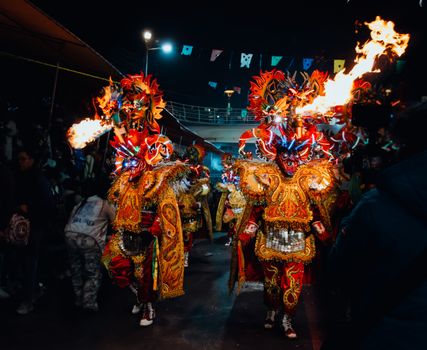 Colorful performers in fiery costumes during Bolivia's Diablada festival, showcasing vibrant cultural traditions.