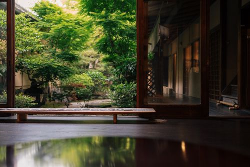 Free A tranquil view of a Japanese garden seen through a traditional house in Kyoto, Japan. Stock Photo
