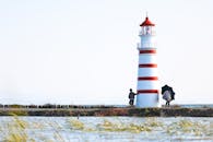 Coastal Lighthouse Scene with People and Umbrella