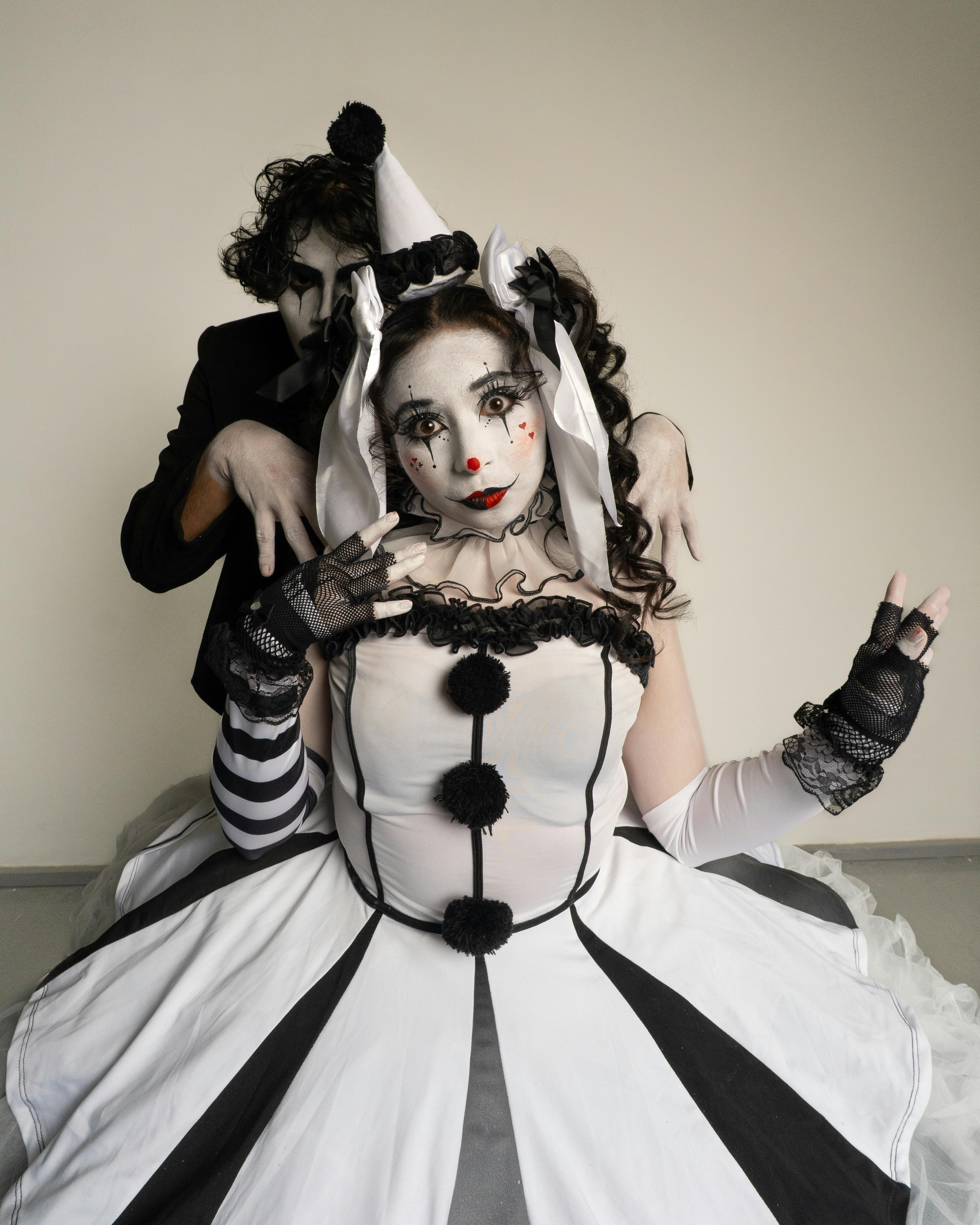 Ücretsiz Palyaço kostümleri giymiş ve sanatsal makyaj yapılmış iki kişi, tiyatrovari bir pozda. Stok Fotoğraflar