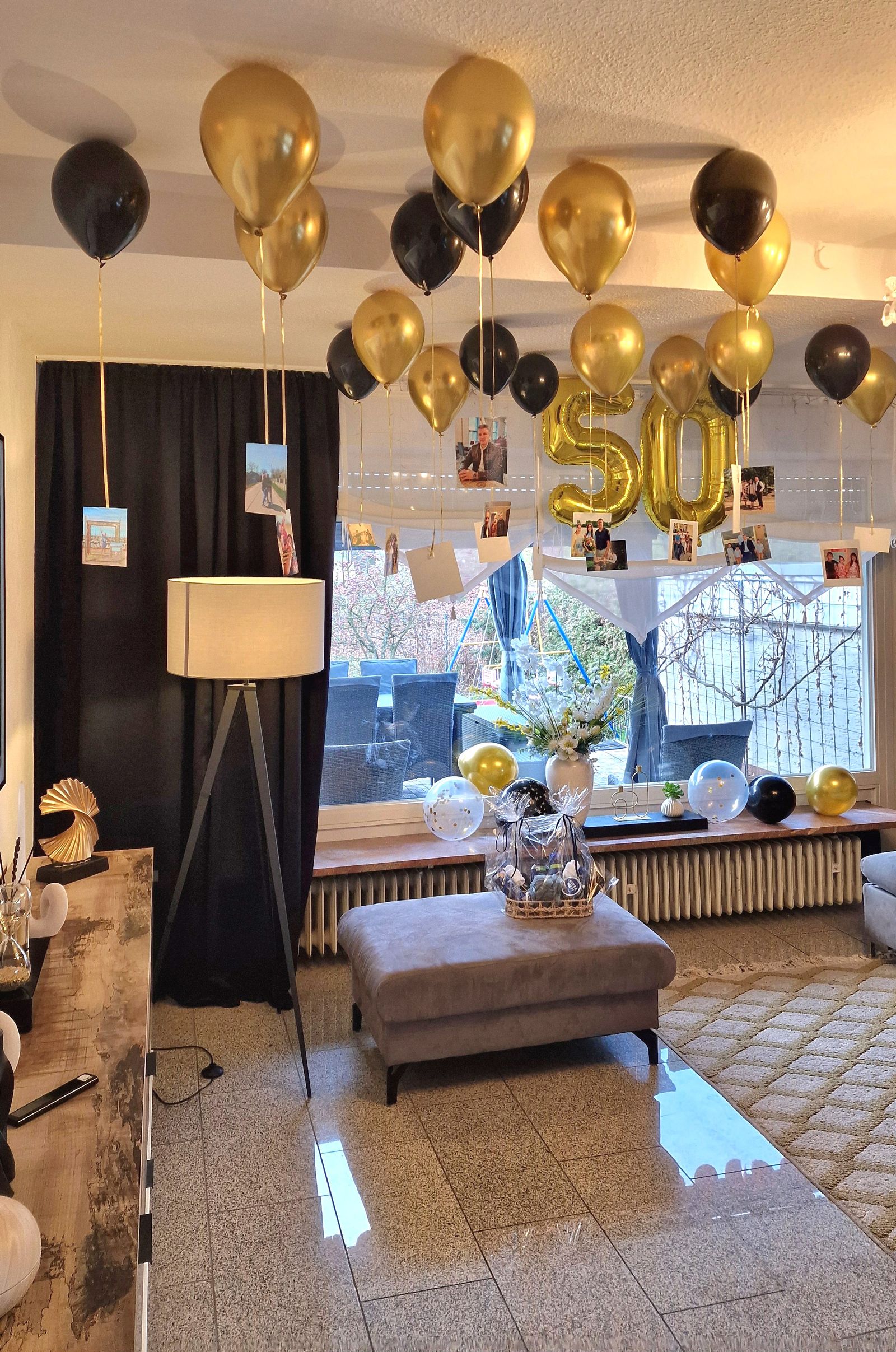 Elegant milestone birthday room decorated with gold and black balloons