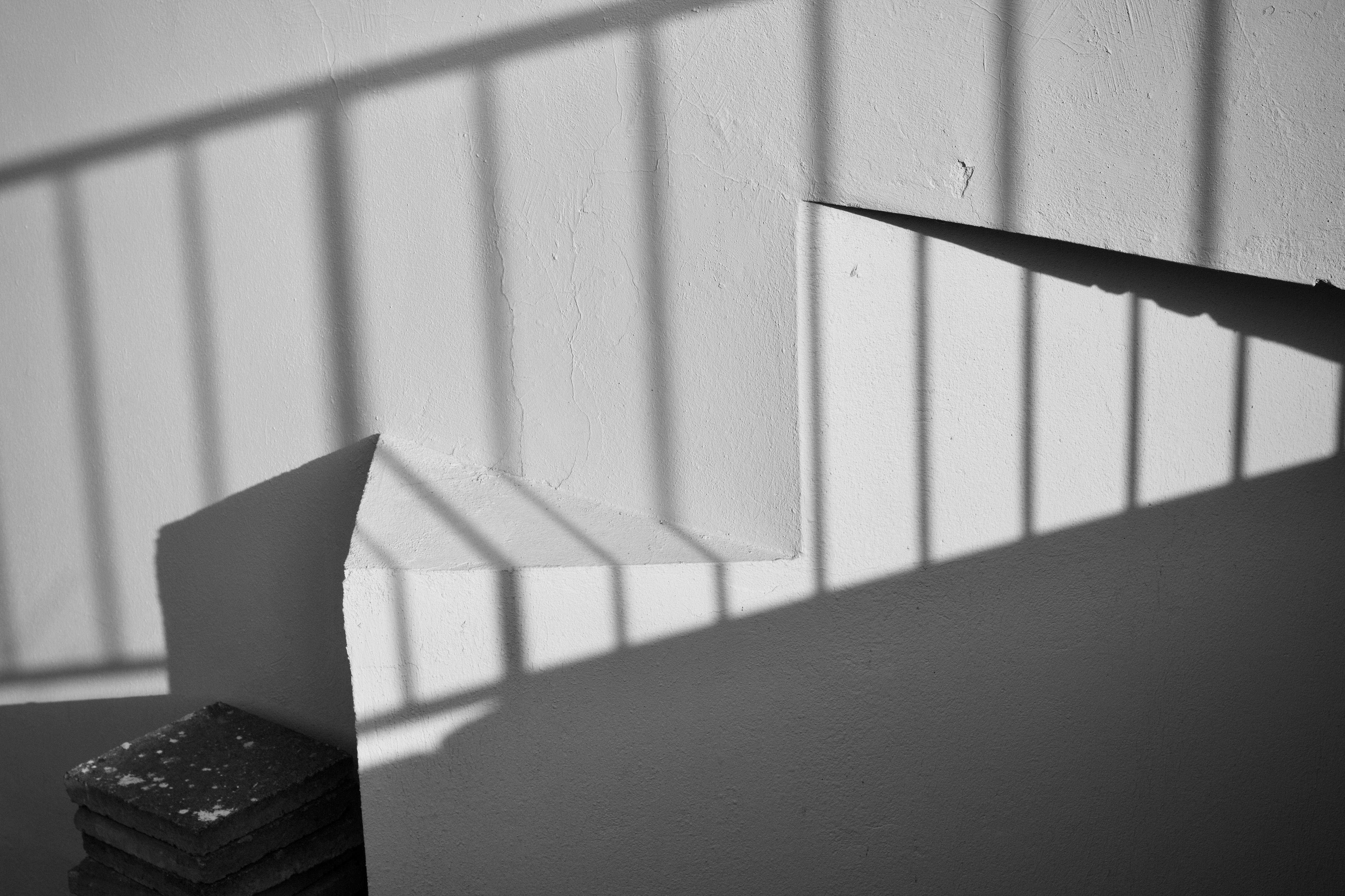 Gratis Immagine monocromatica di ombre geometriche sulla parete di una scala. Foto a disposizione