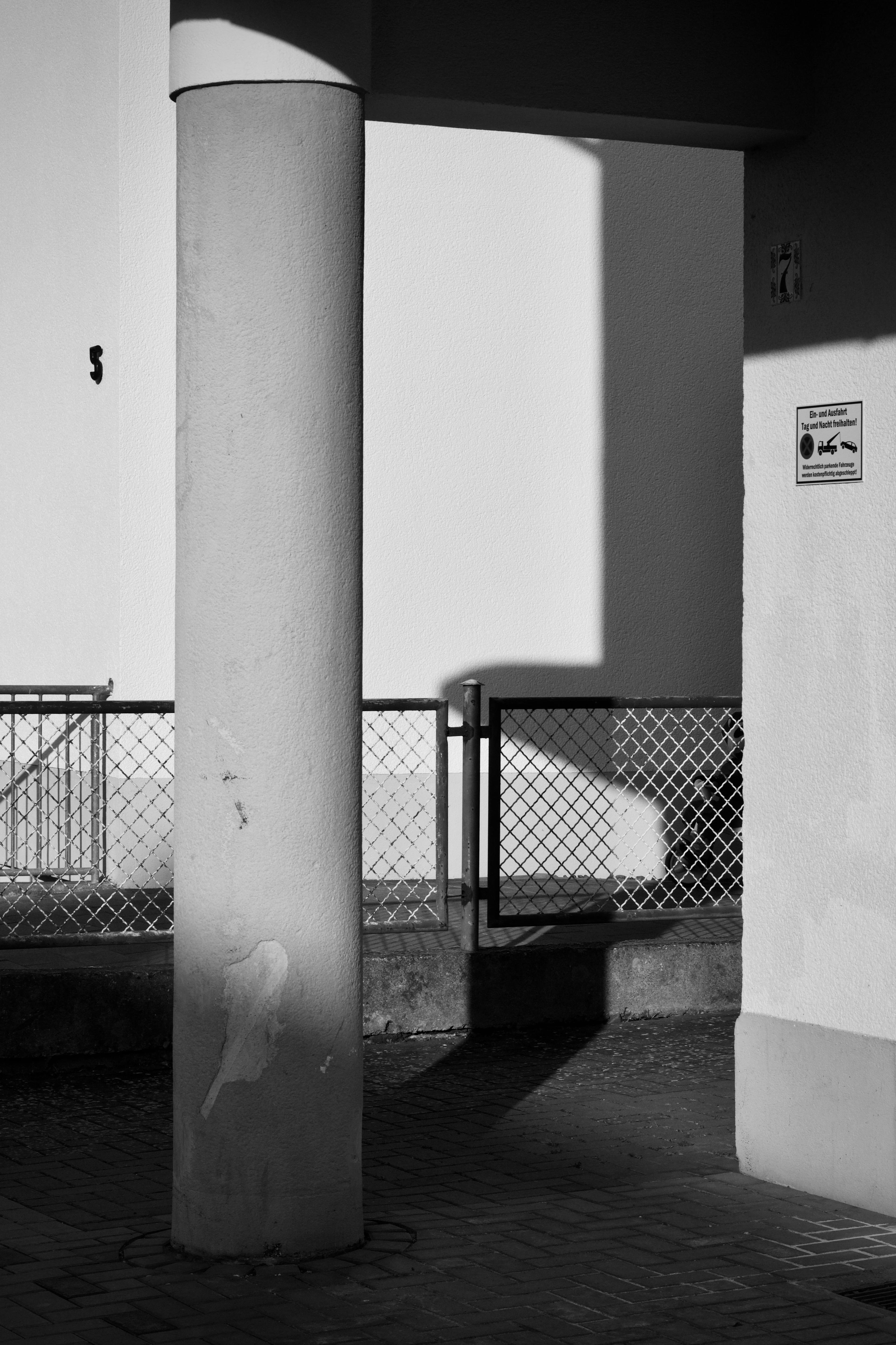 Gratis Escena urbana en blanco y negro que captura sombras, luces y estructuras arquitectónicas. Foto de stock