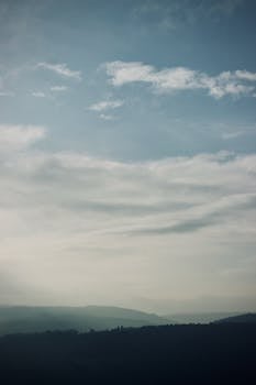Peaceful mountain range with a cloudy sky, creating a tranquil and calm atmosphere.