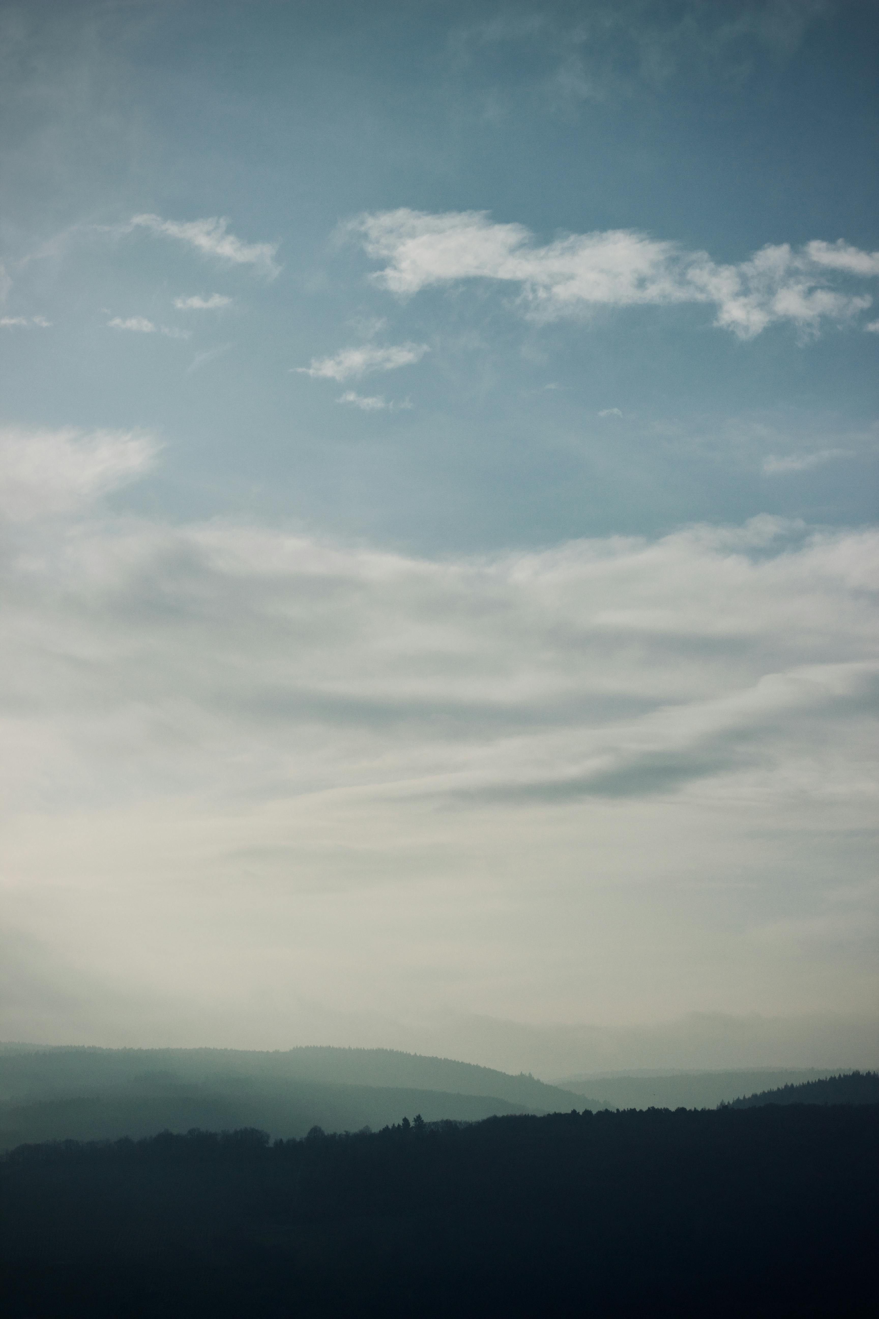 gratis Een vredig berglandschap met een bewolkte hemel, wat zorgt voor een rustige en kalme sfeer. Stockfoto