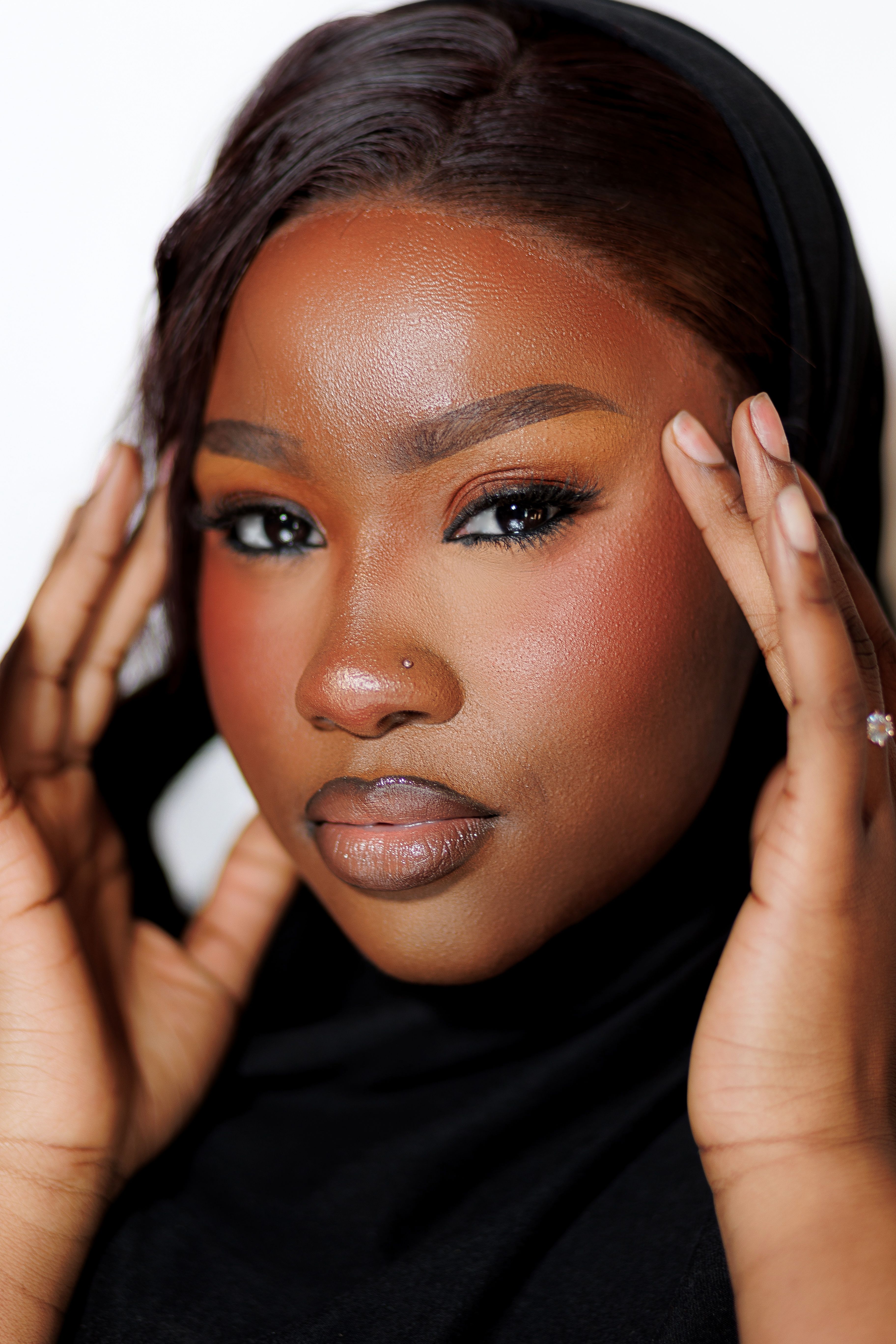 Close-up portrait of a beautiful woman with striking makeup and a confident expression.