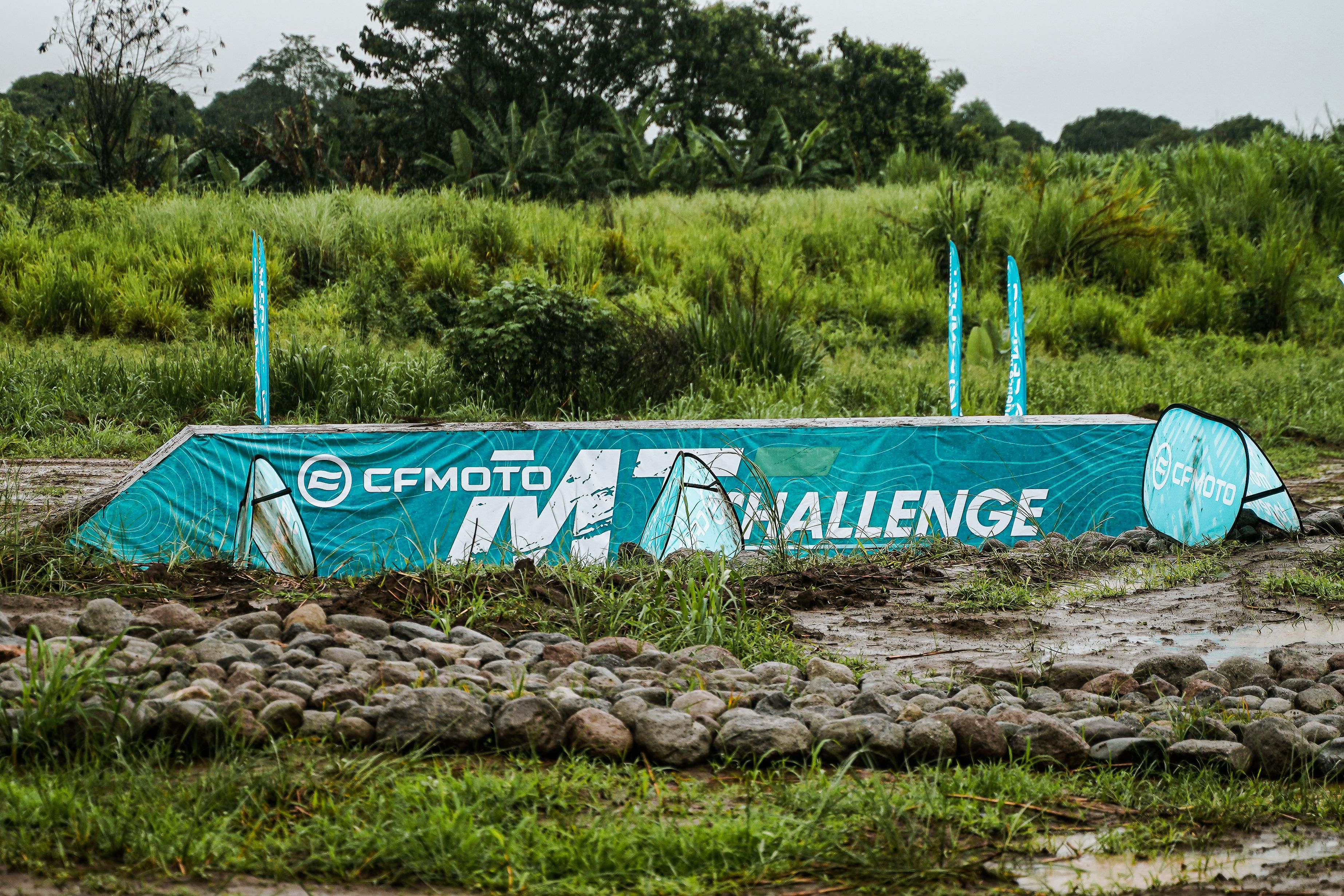 A banner for the CFMOTO challenge set in lush greenery in Bulakan.