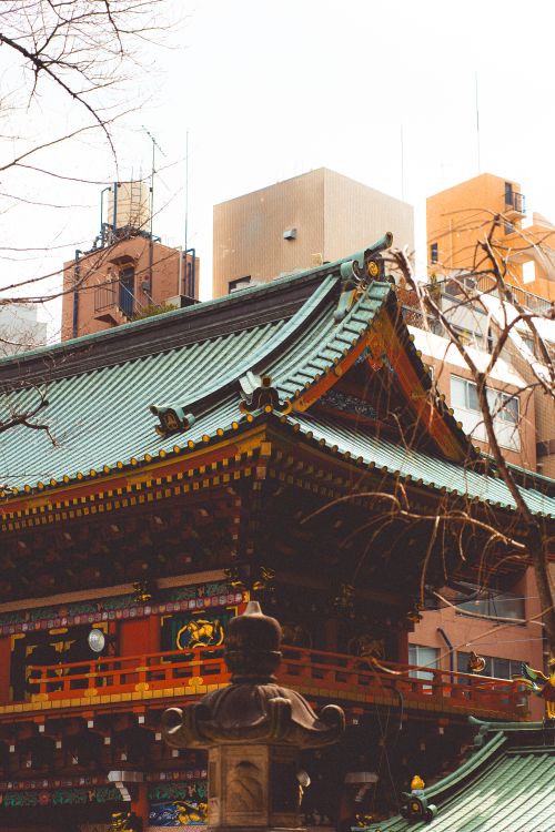 Free A traditional Japanese temple roof contrasts with modern Tokyo buildings, embodying cultural heritage. Stock Photo