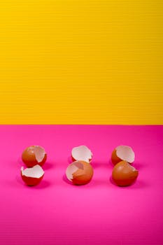 Six brown eggshells on pink and yellow background with vivid colors.