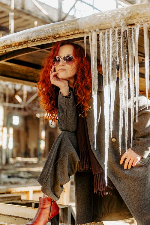 Free Fashionable woman in coat and sunglasses posing with icicles indoors. Stock Photo