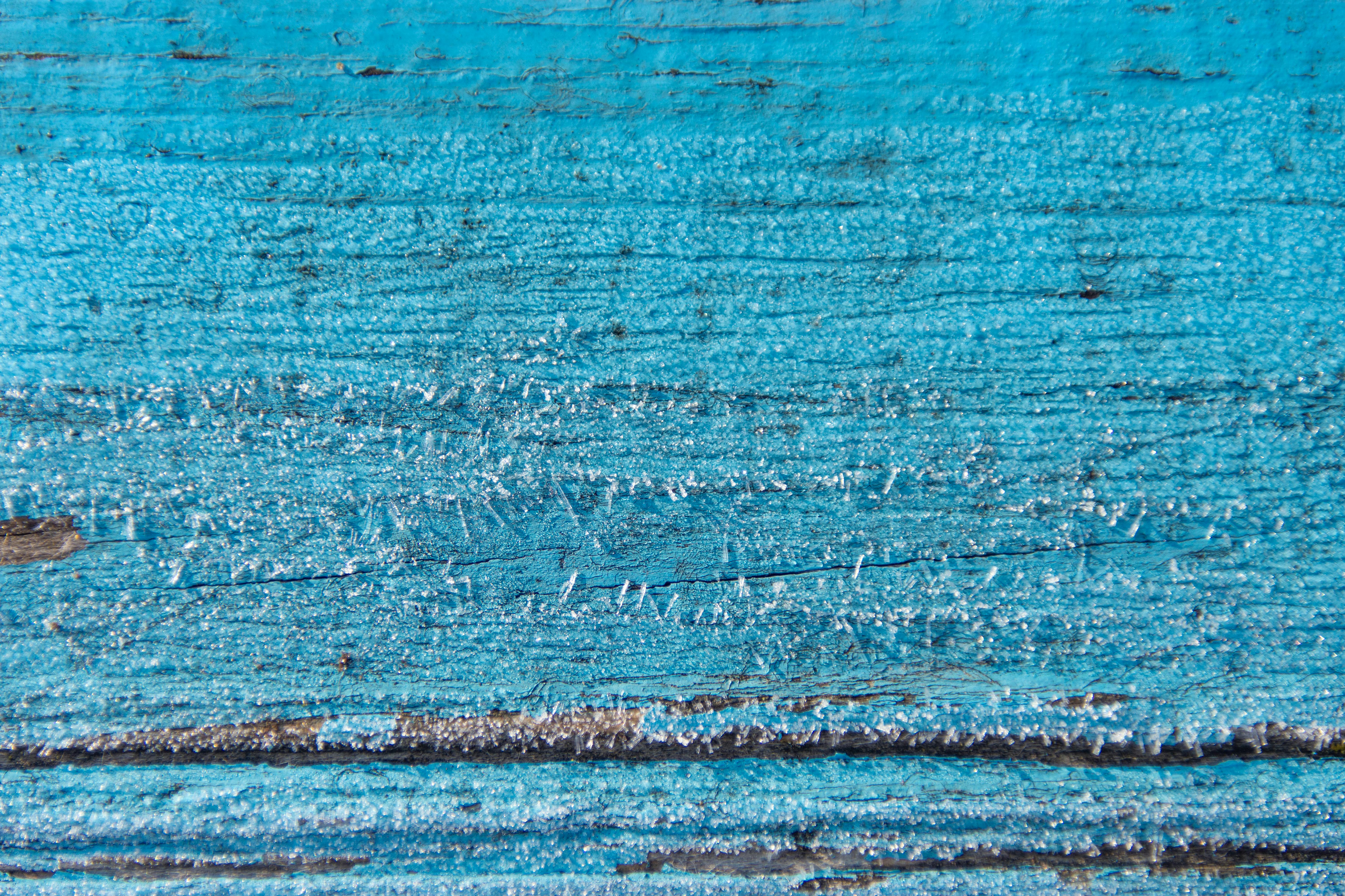bezplatná Detailní záběr námrazy na starém modrém dřevěném povrchu, zobrazující složité textury a přírodní vzory. Základová fotografie