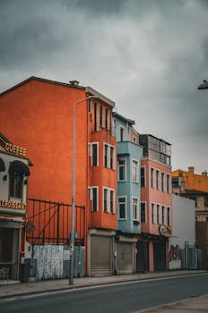 Vivid street with colorful buildings under a cloudy sky, showcasing urban architecture.
