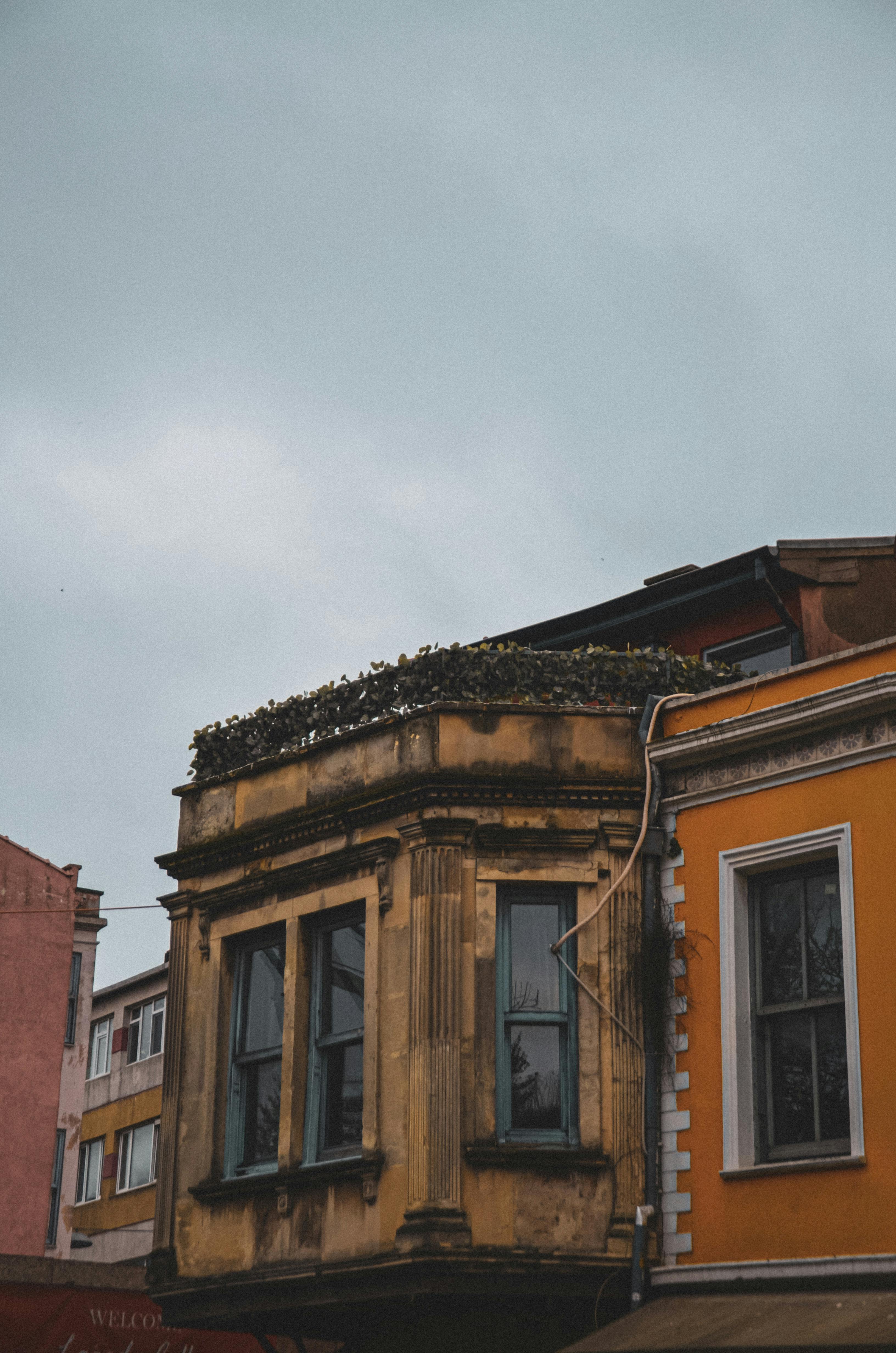 Free An aged, ornate building facade under a gray sky, showcasing classic European architecture. Stock Photo