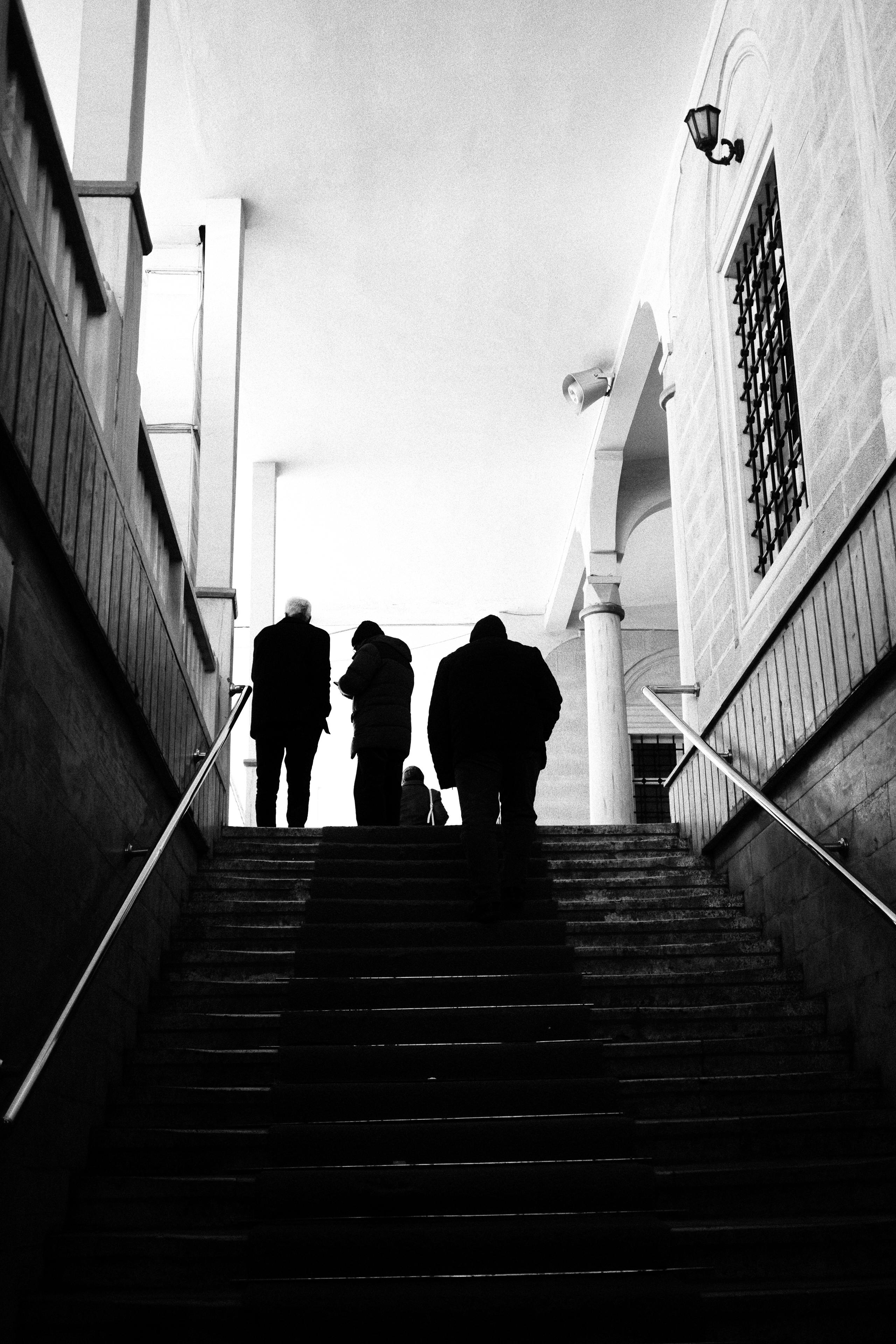 無料 屋内の階段に立つ人々のシルエットの白黒写真。 写真素材