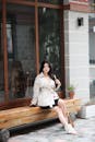 Stylish Asian Woman Sitting on Wooden Bench
