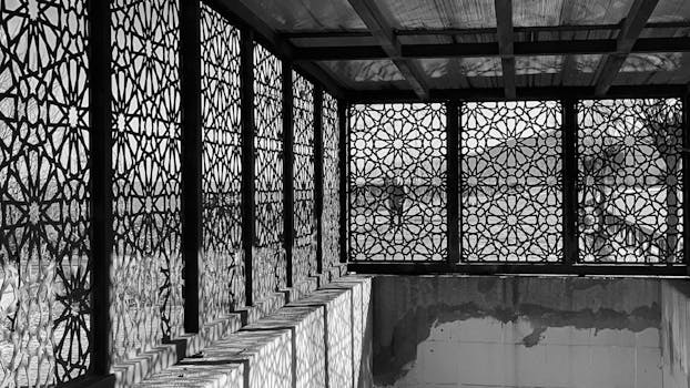 Black and white image showcasing intricate geometric patterns of a screened patio casting detailed shadows.