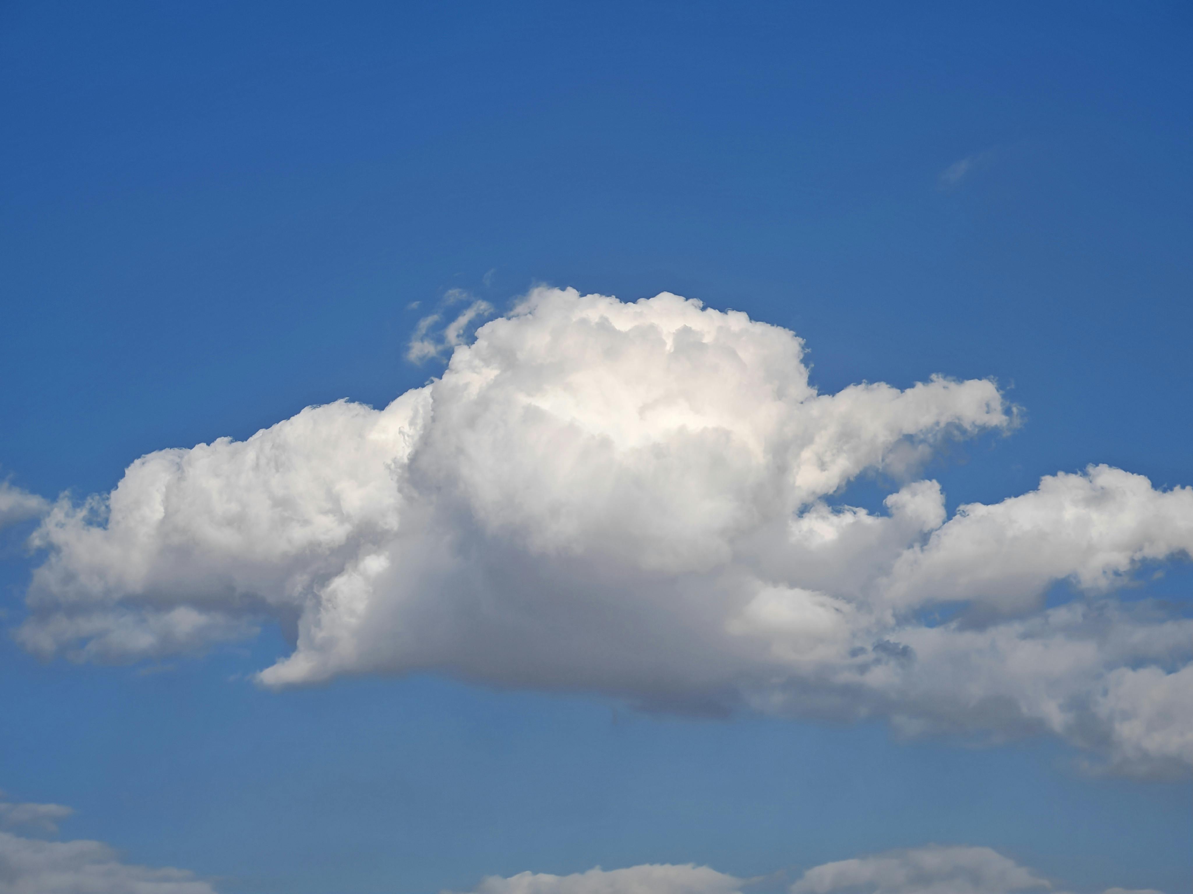 Gratuit Un frumos nor cumulus pufos pe un cer albastru senin, perfect pentru fundaluri naturale. Fotografie de stoc
