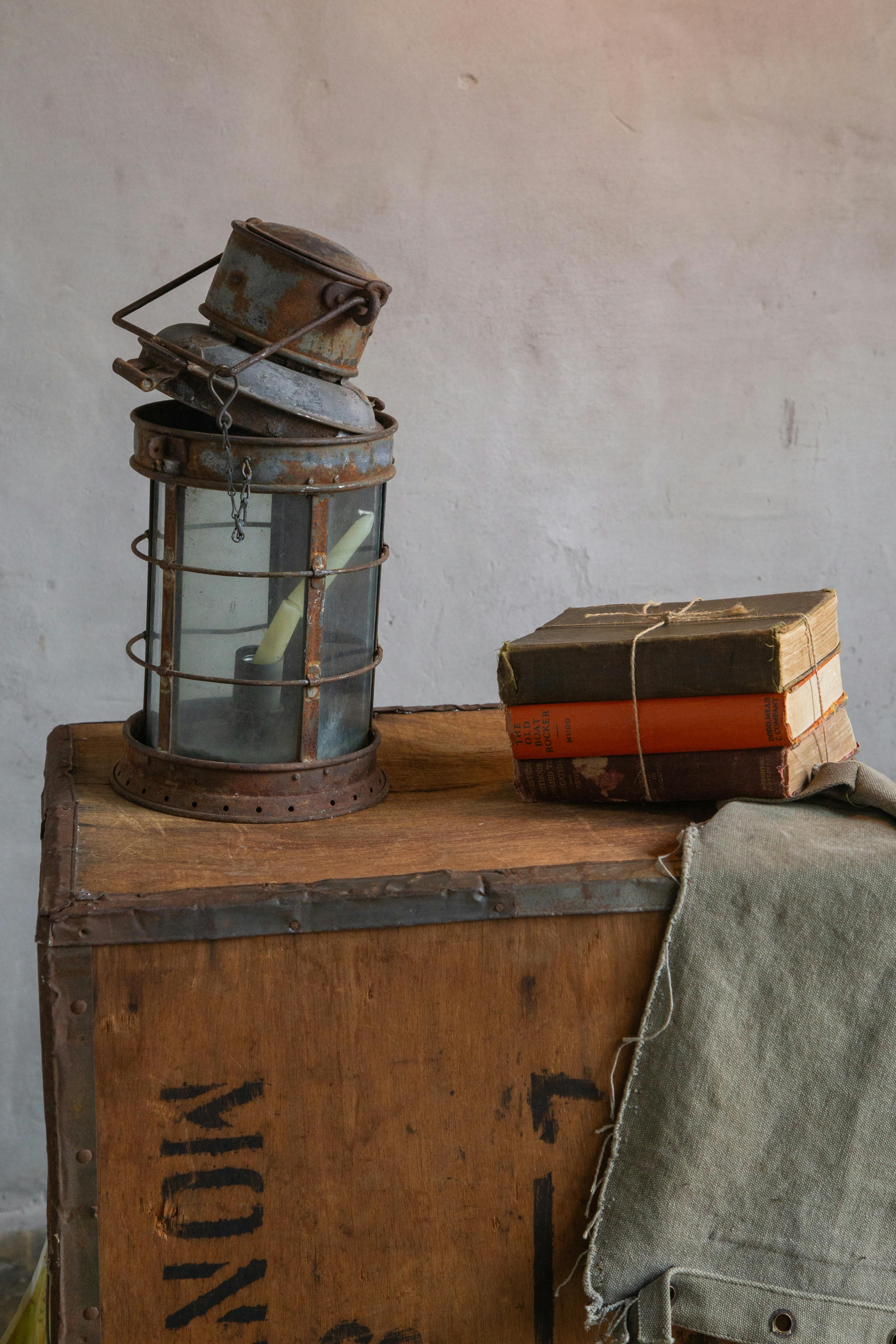 бесплатная Художественная винтажная композиция с антикварными книгами и декоративным фонарем на деревянном ящике. Стоковое фото