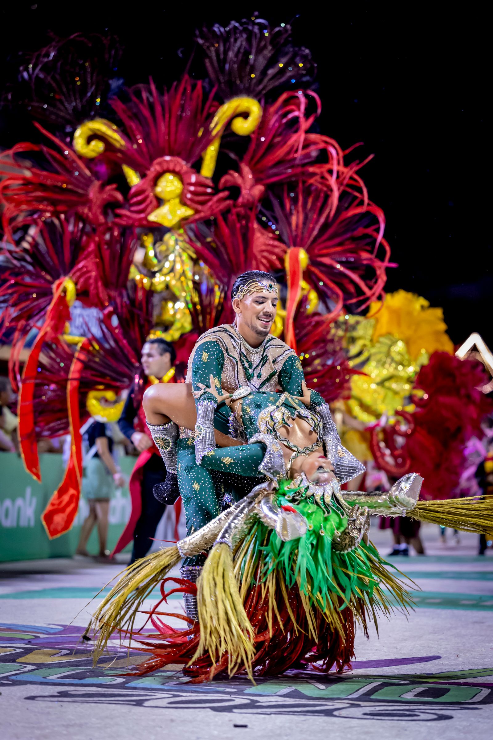 Samba — costumed carnival couple performing joyfully in a night parade. Stock photo.